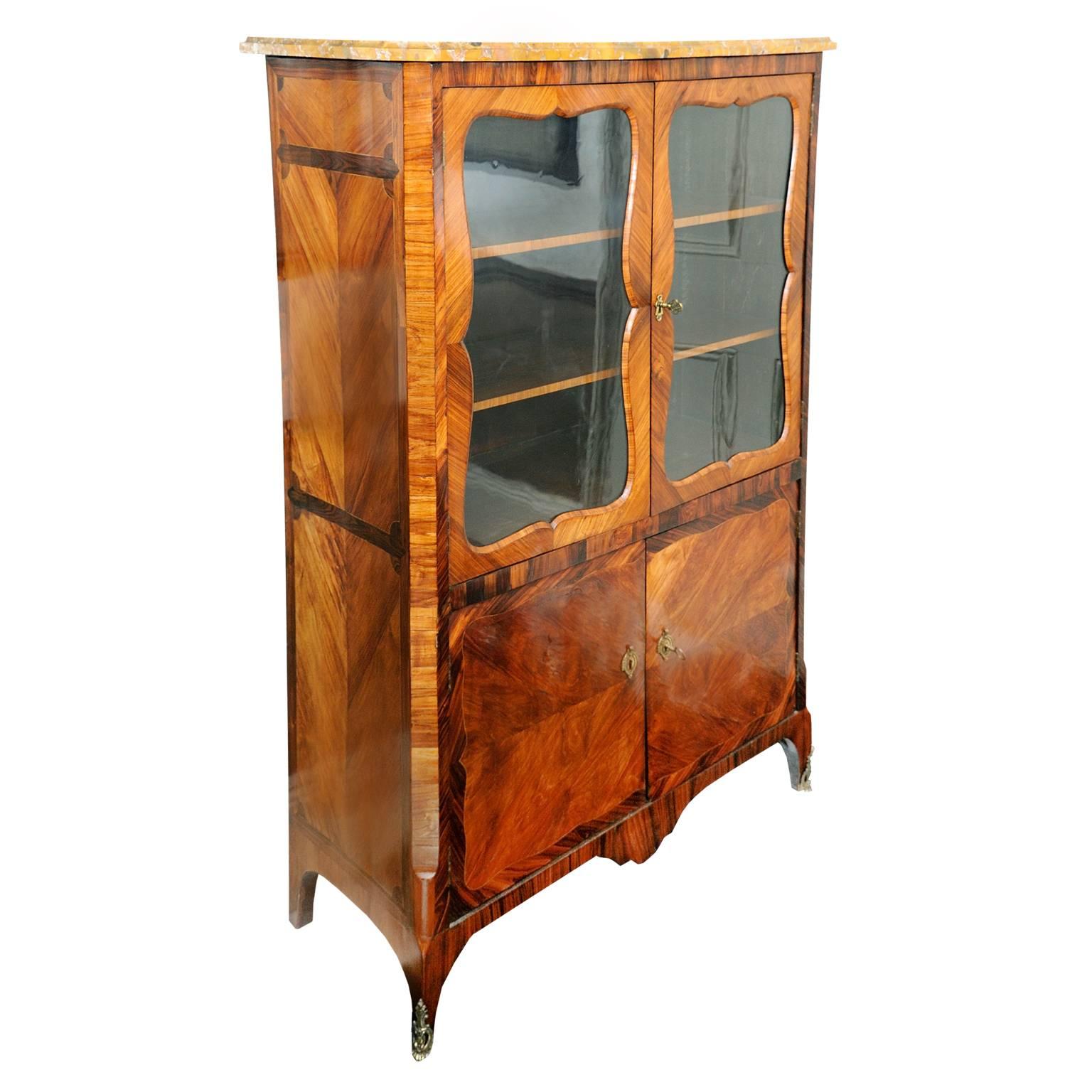 This is a stunning French Louis XV transitional period glazed display cabinet, featuring a fully shelved interior and gold colored brush alpine marble top. 

The cabinet is finished with high quality kingwood and rosewood parquetry detailing on a