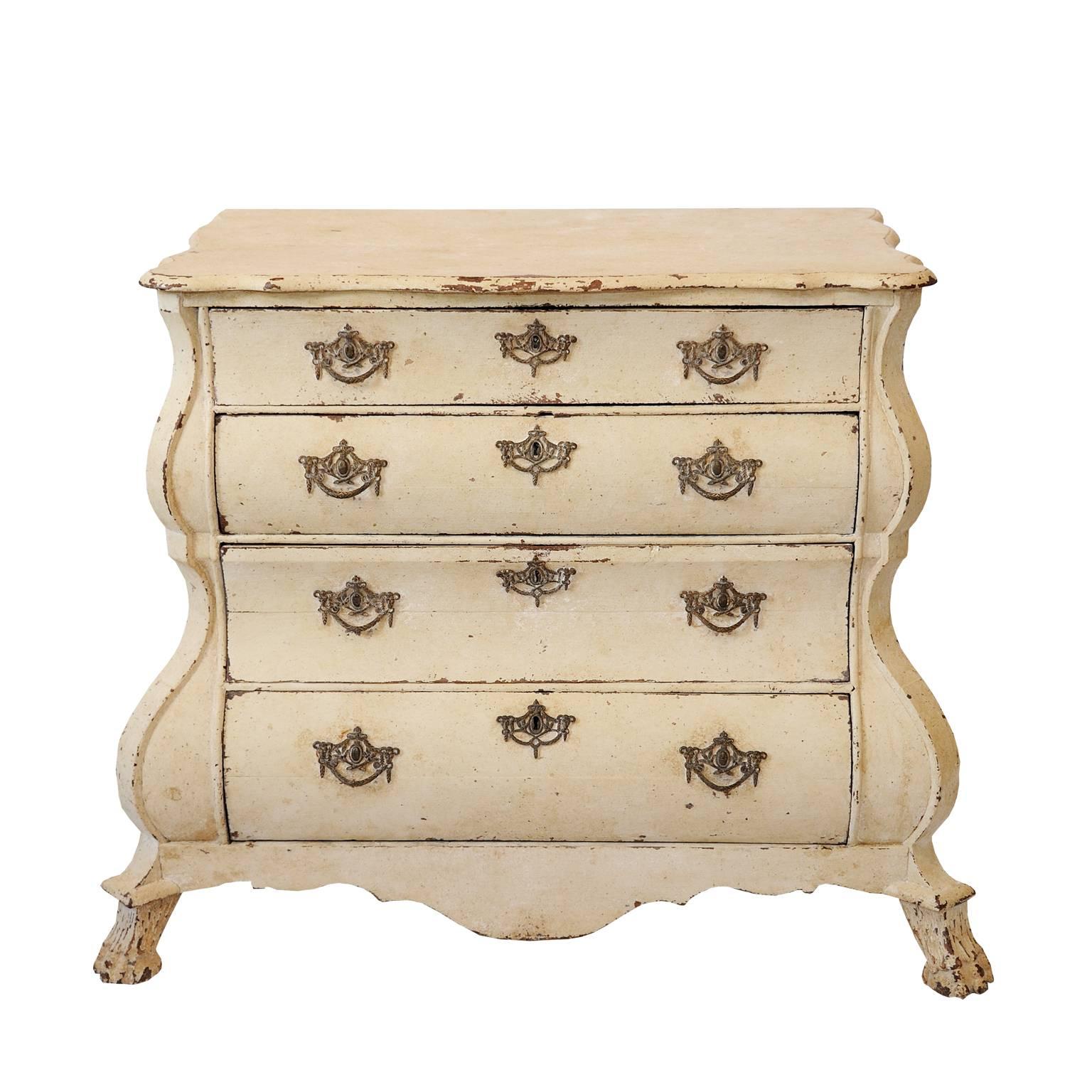 
This is a lovely Dutch, mid-18th century, small painted four-drawer baroque bombe shaped commode chest of drawers. Decorated on an oak carcass with original brass handles and escutcheons, also with original locks and Lions paw feet to the front.