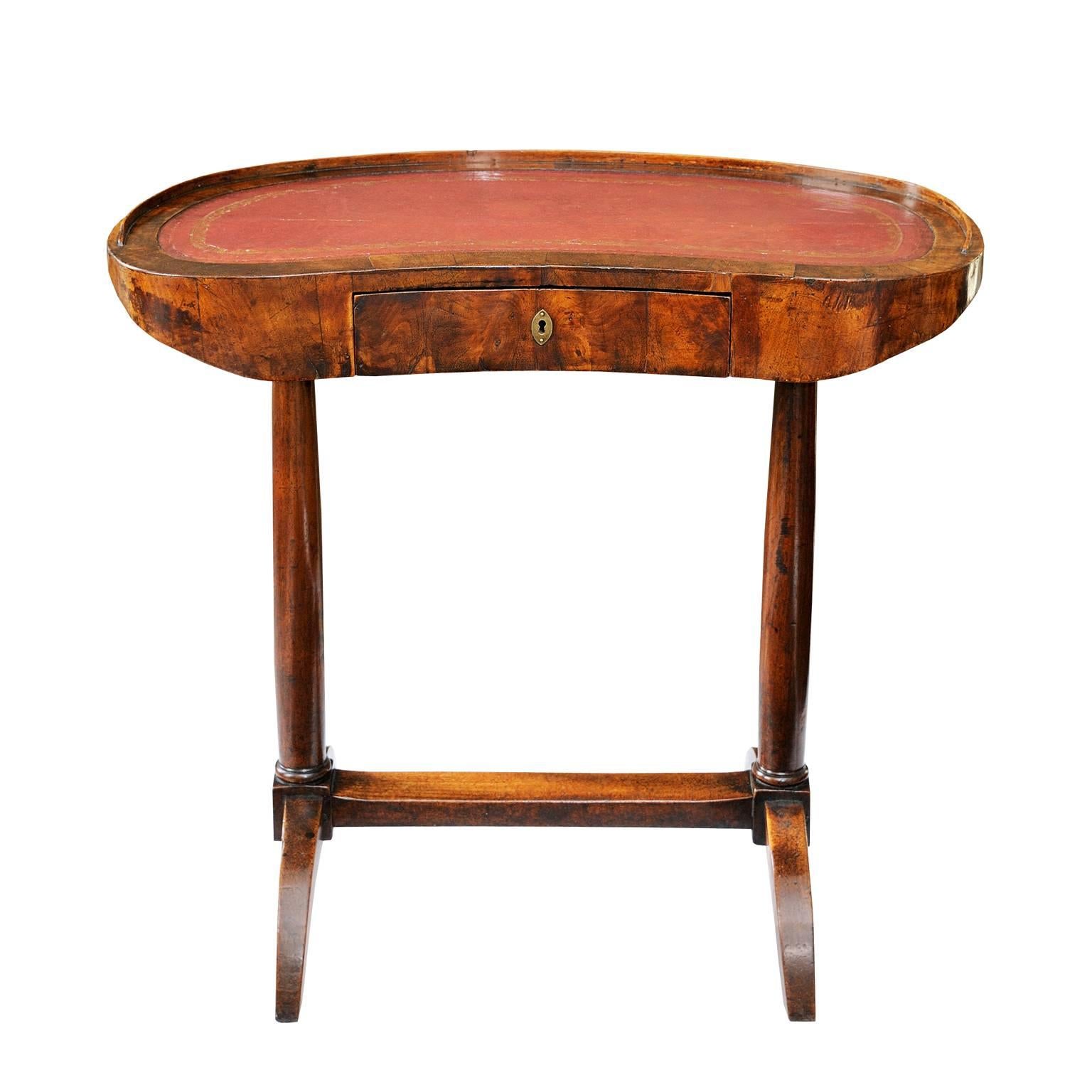 A French Napoleonic Empire period walnut kidney-shaped writing desk or dressing table with a small drawer to the front and a tooled leather top. (c.1820)