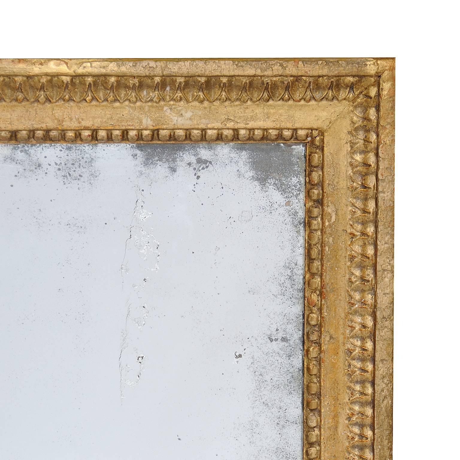 This is a rather wonderful late 18th century traditional French Louis XVI period giltwood mirror with lamb's tongue and bead carved moulding, retaining its original mirror plate, circa 1780.
           