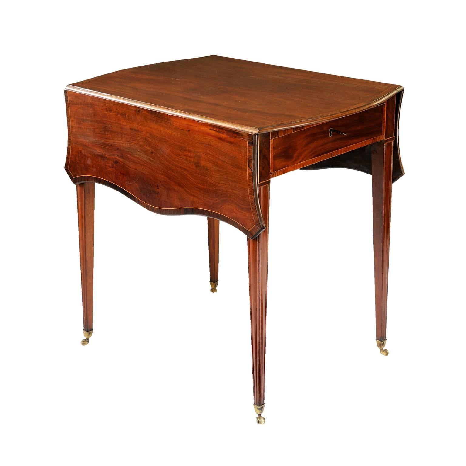 18th Century English George III period mahogany Pembroke table, with butterfly drop-leaves, standing on square tapered legs and brass cup castors. Single drawer with original lock and key, stringing and cross-band decoration (c.1780).