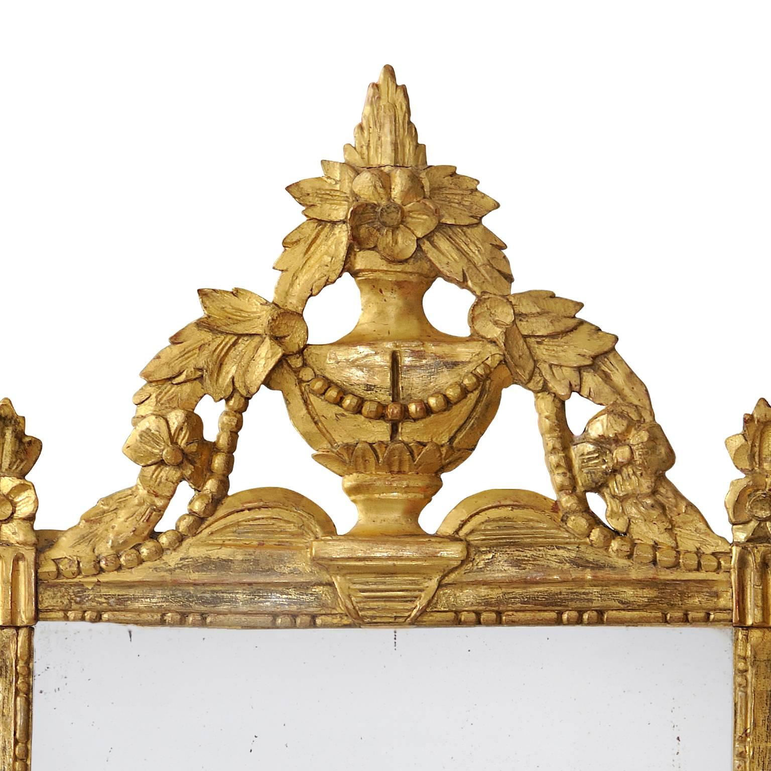 This is a stunning French late 18th century Louis XVI period Provencal painted and giltwood, neoclassical mirror featuring beautiful carved urn and floral decoration and retaining its original mirror plate, circa 1780.