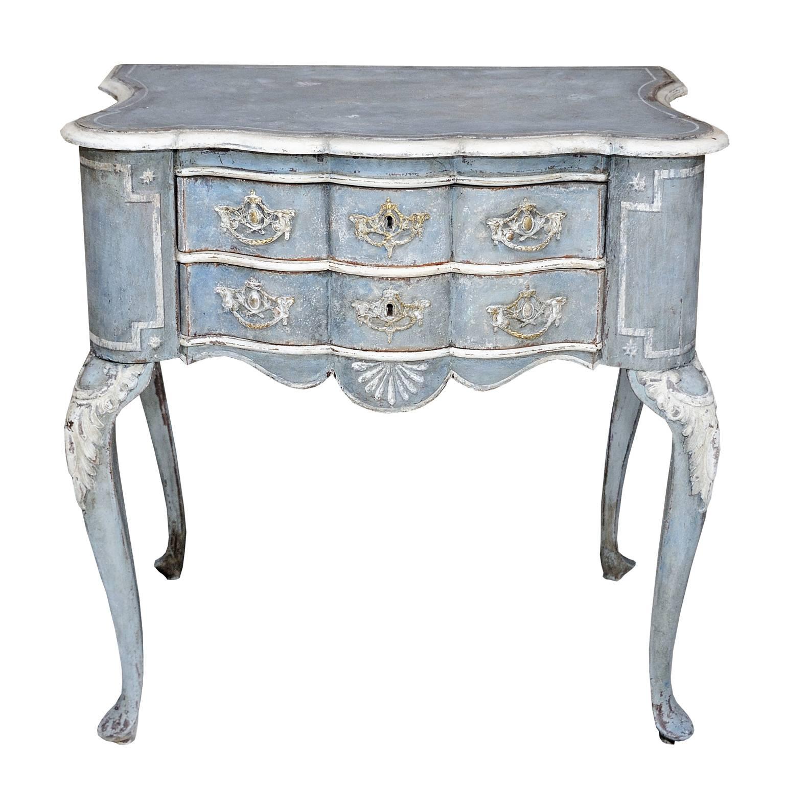 This is a rather charming Dutch 18th century style painted lowboy or side table featuring carved cabriole legs and decorative design features, shaped front and sides with brass handles, circa 1860.