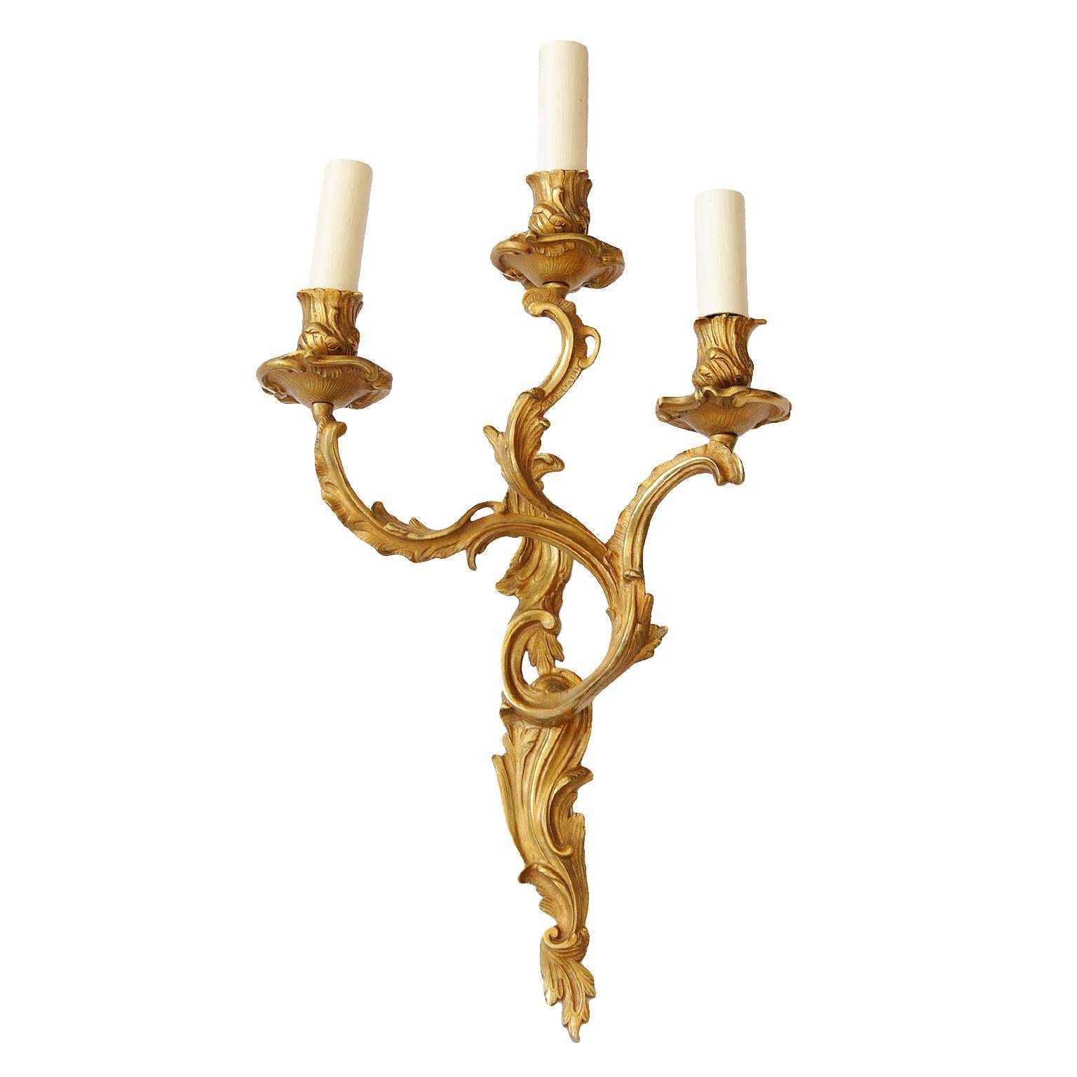 This is a very pretty pair of Louis XV style, late 19th Century Rococo wall lights. These charming three branch wall lights are made in gilt brass and have been rewired and had new electric fittings mounted. circa 1890