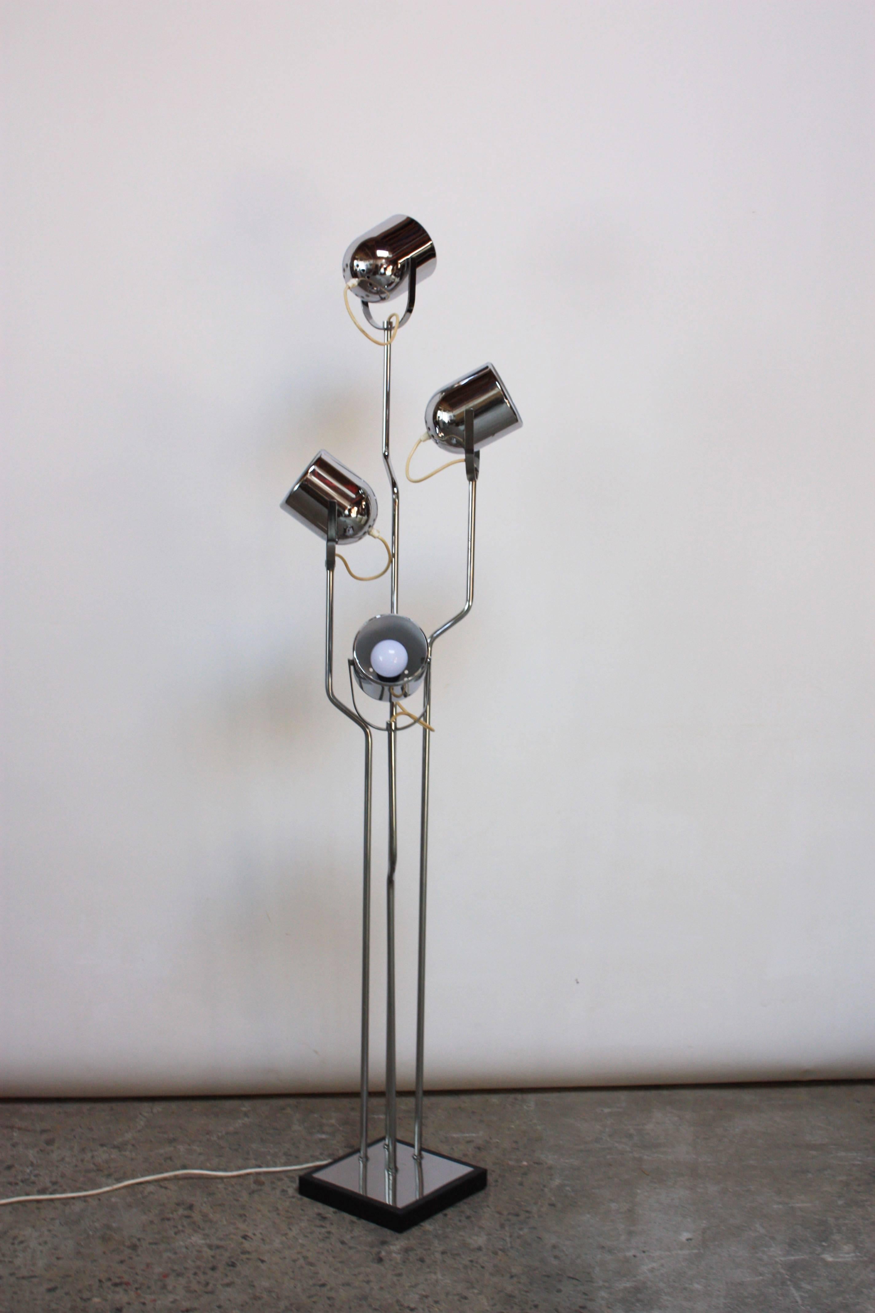 This 1970s Reggiani chromed-steel floor lamp features four fully adjustable fixtures affixed to a corresponding chromed-steel bent rod. 
There is a slight dimensional variation, dependent on how the fixtures are adjusted, but the overall dimensions