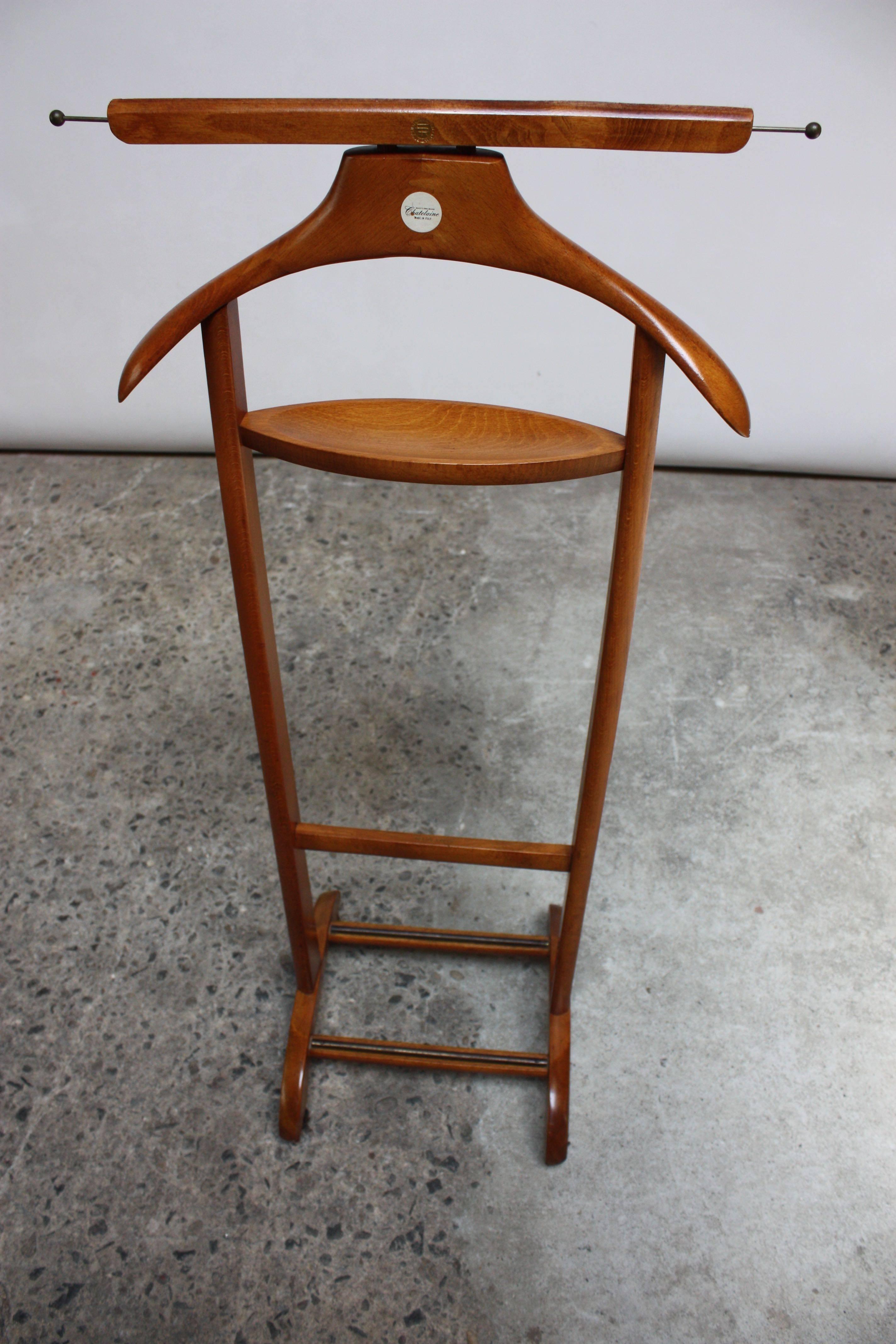 This walnut valet on four caster wheels was designed by Ico Parisi for Fratelli Reguitti in the 1950s. It retailed at Macy's (as indicated by the 'Macy's own brand Chatelaine made in Italy' sticker that remains fully intact). The hanger is branded