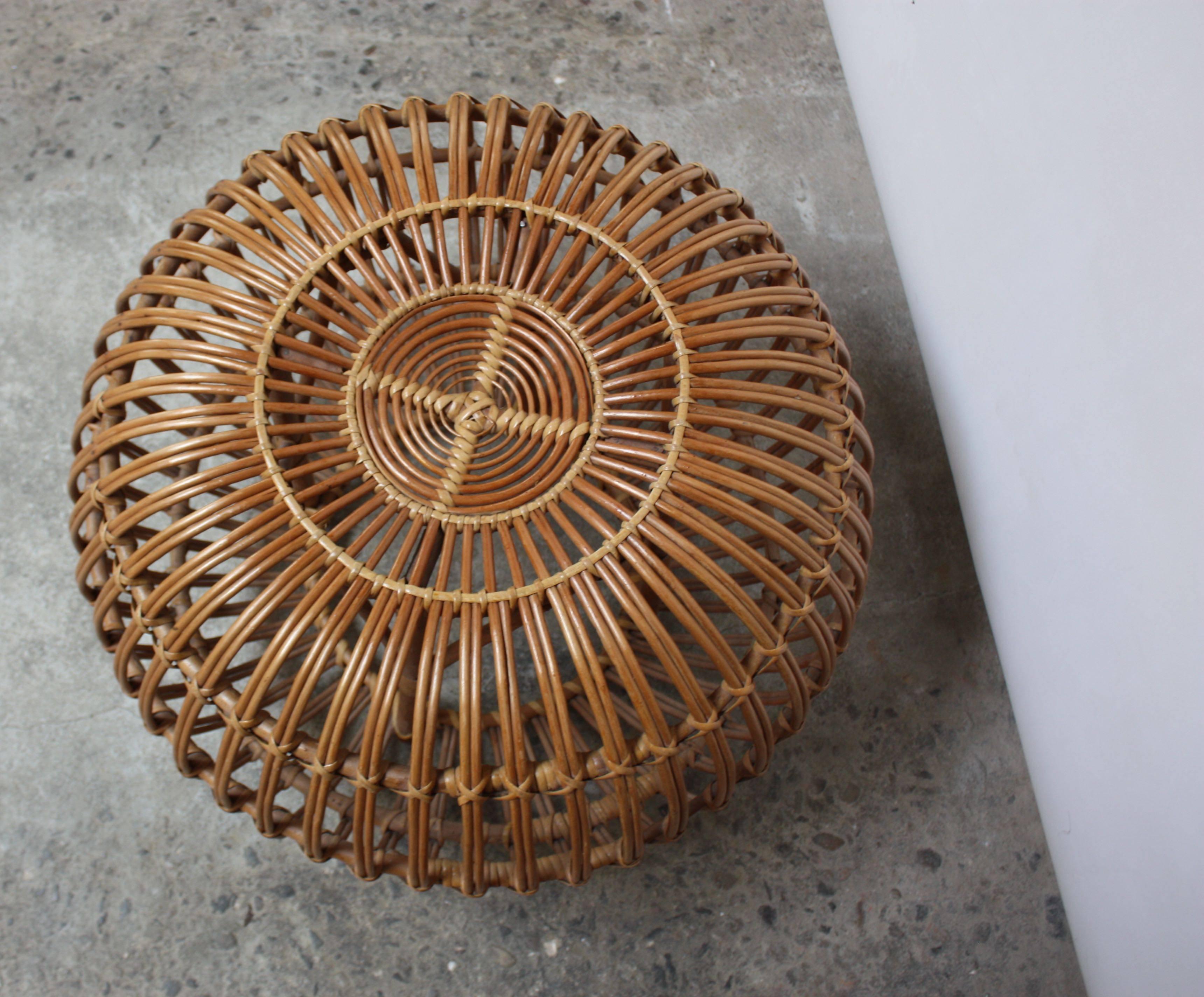 This rattan pouf or ottoman was designed by Franco Albini for Vittorio Bonacina in the 1950s and is comprised solely of bent-rattan weaving. There is minor loss (the 'cross stitch' is missing on a few strands of the rattan). Otherwise, all vertical