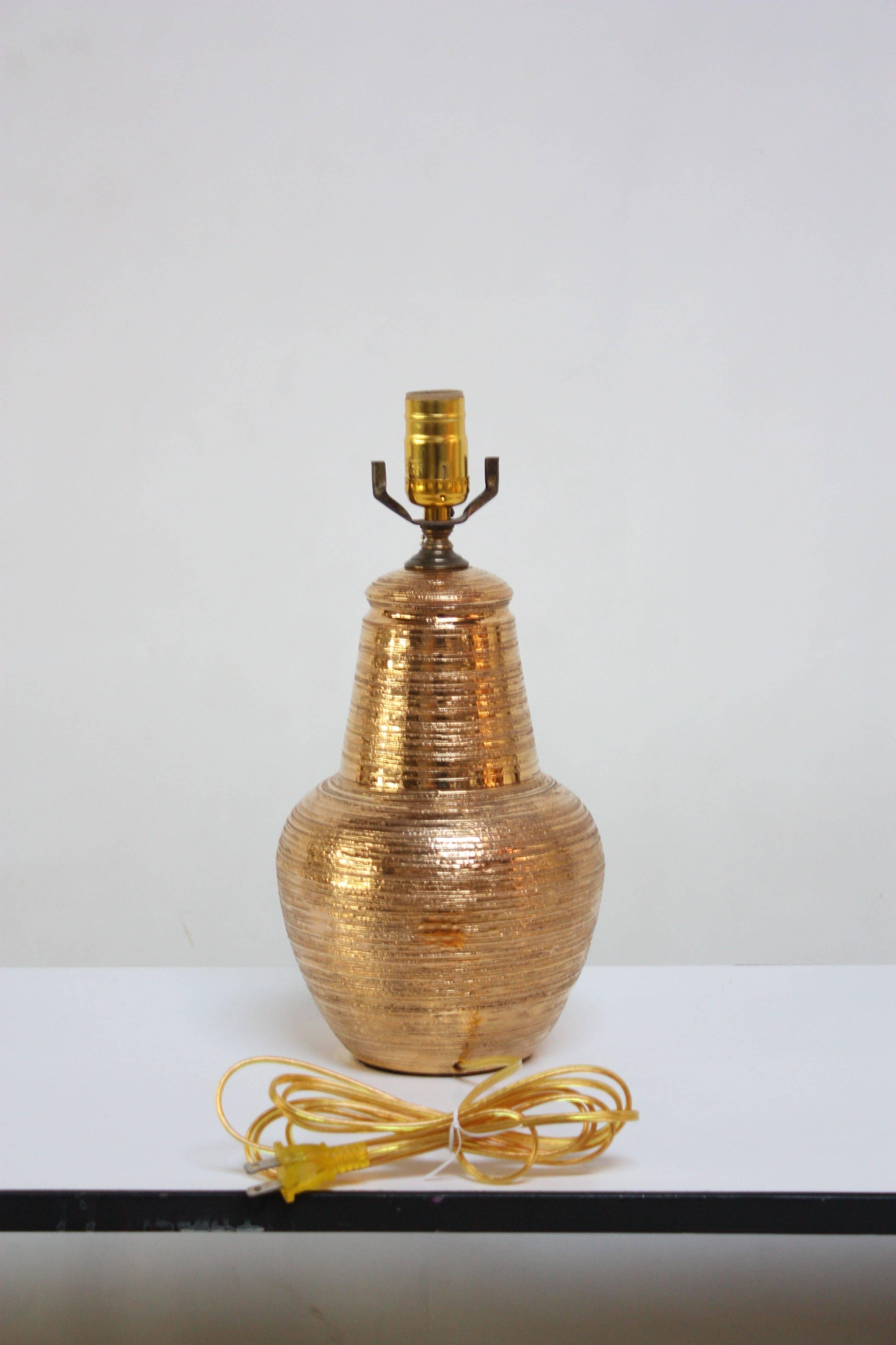 Lampe de table en céramique italienne en glaçure dorée texturée. Cette lampe en céramique italienne à la texture lourde présente une décoration appliquée 