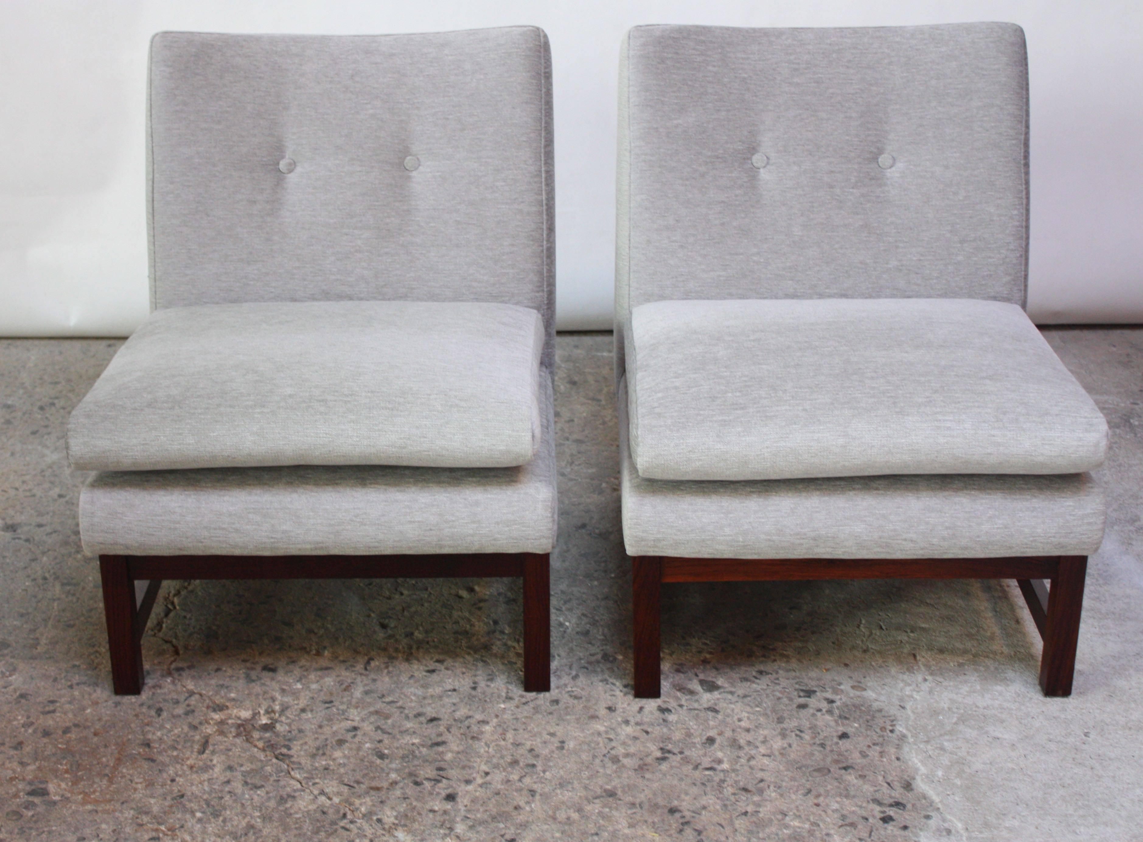 These Norwegian slipper chairs are composed of rosewood bases and sculptural frames. The top cushion is adjoined to the frame via two metal 'buckles' which hook to metal loop attachments on the cushion. (Top cushion can be removed for less padding,