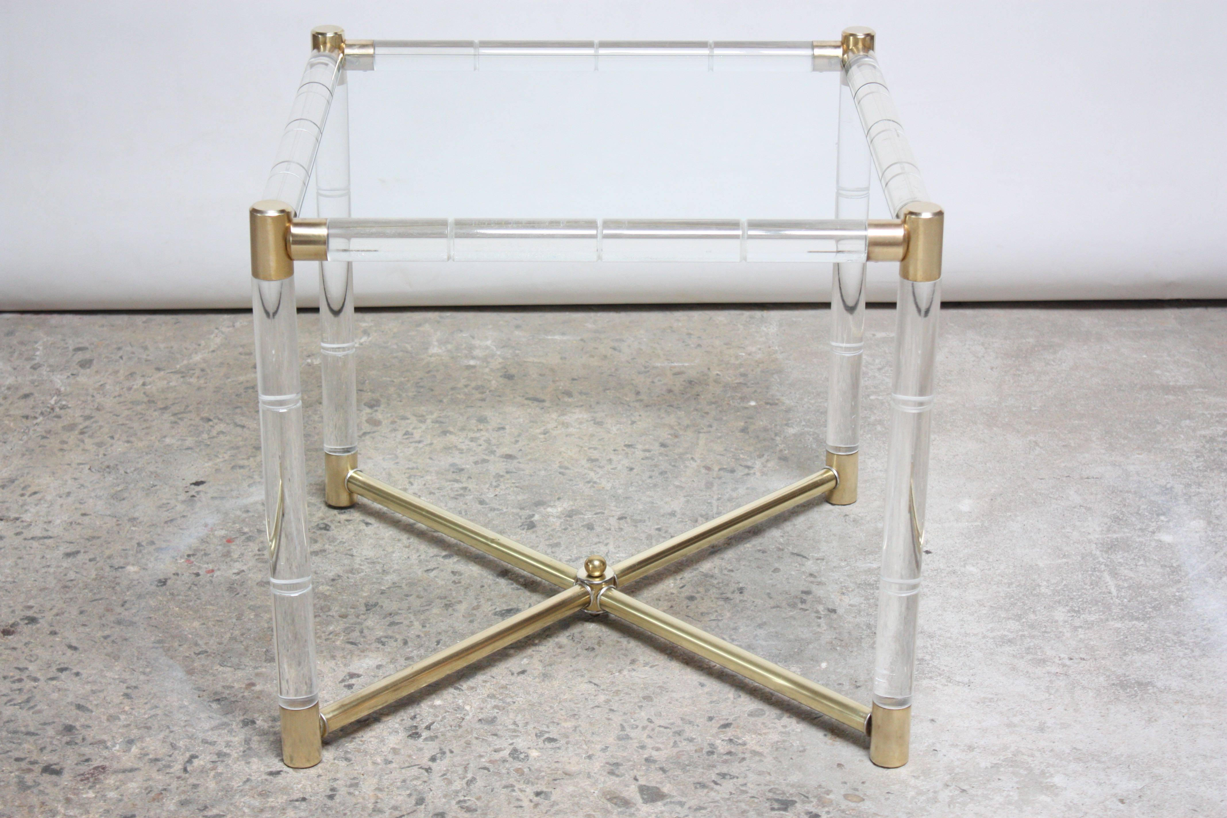 Elegant side table designed by Charles Hollis Jones in the 1960s for his 'Regency Bamboo' line comprised of a polished brass 'X' base and caps, and bamboo-styled Lucite rails. Brass has been hand-polished to a perfect satin finish. There is patina