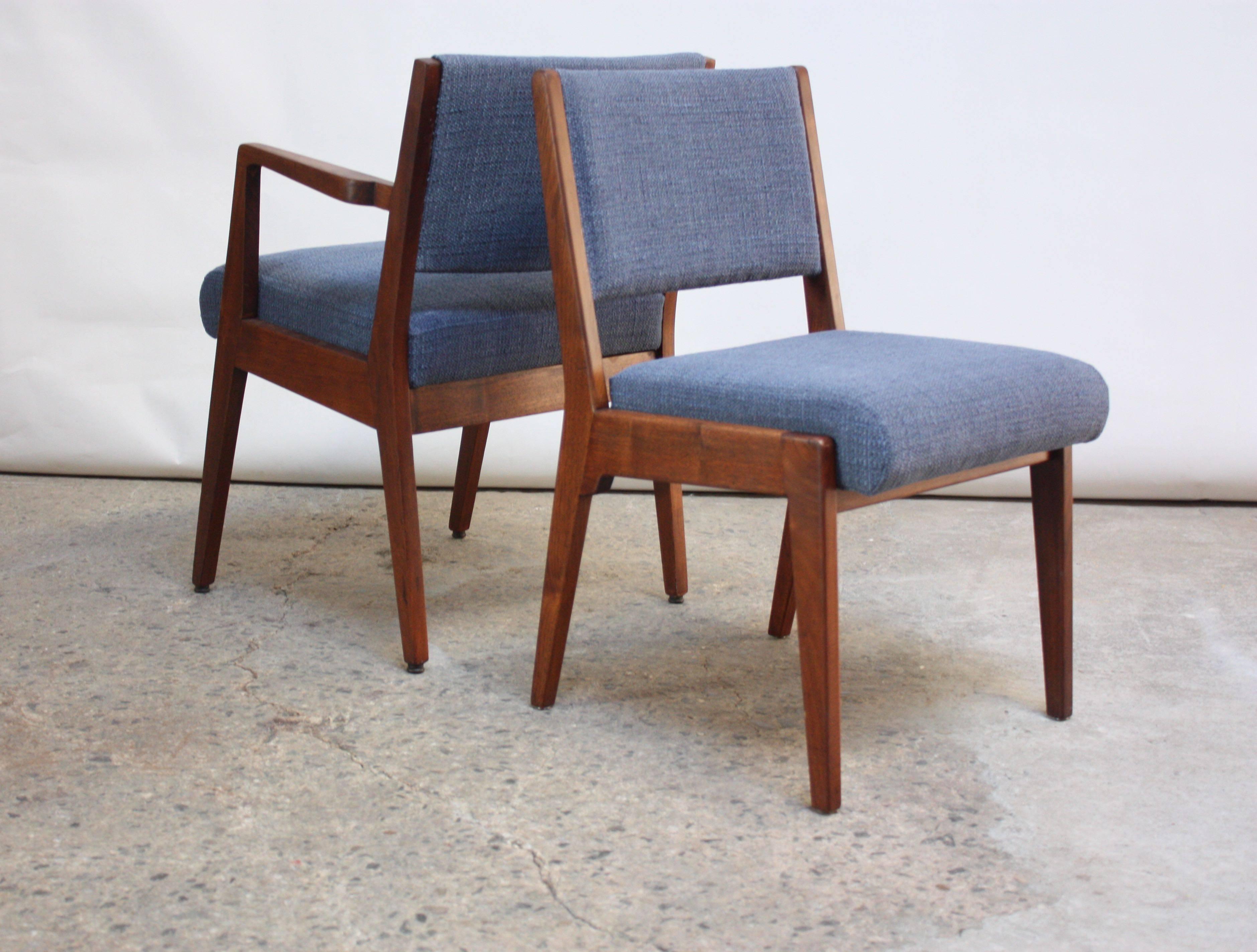 This set of early Jens Risom dining chairs, designed for his eponymous manufacturing firm, includes four side chairs and two captain's chairs. The sculptural walnut frames boast elegant lines and a rich walnut tone. 
The tweed upholstery is new, as