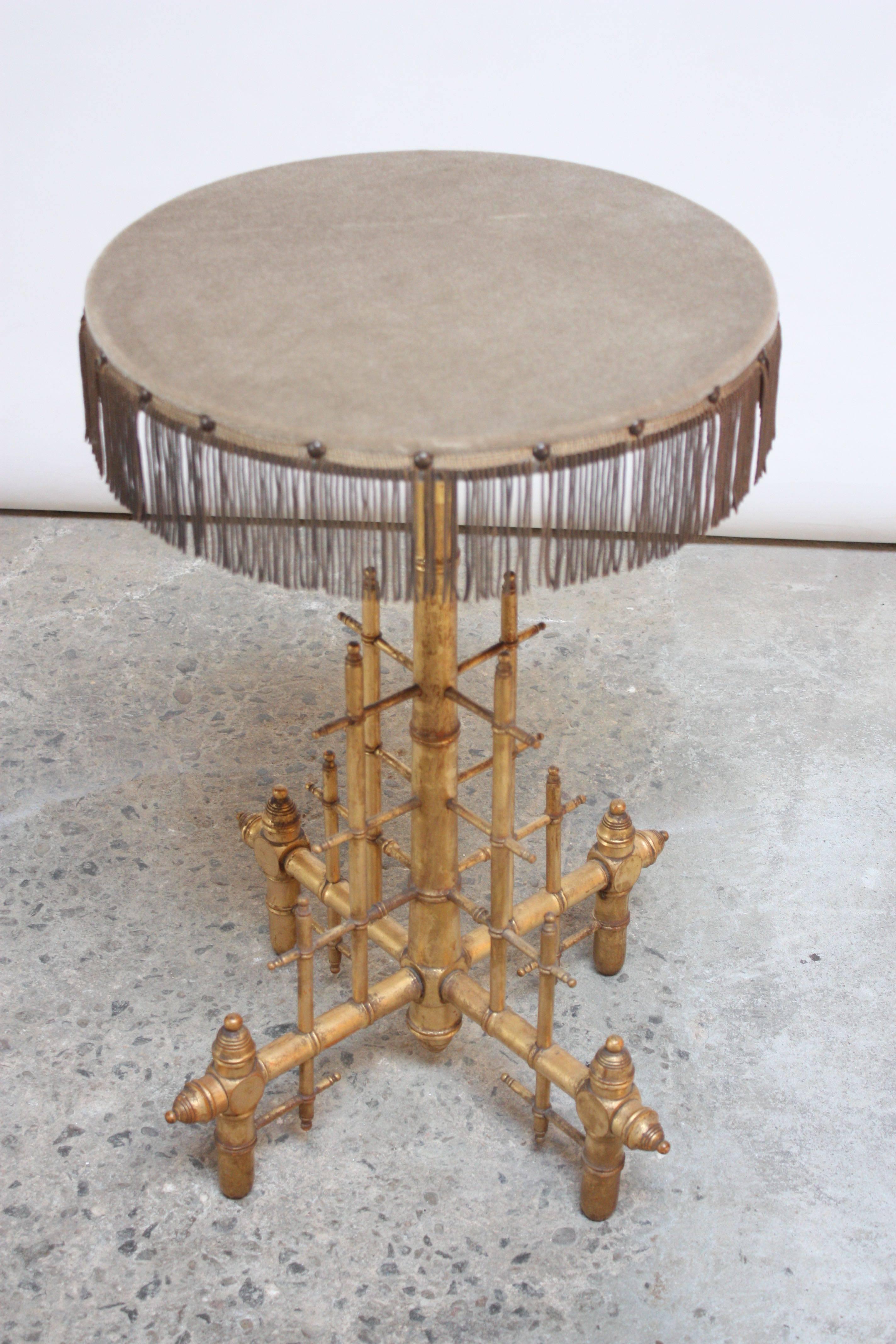 Unique and whimsical drum table comprised of a gilded wooden base depicting pipes and fittings. The original textile was replaced however it retains the original tassels and upholstery tacks.
 