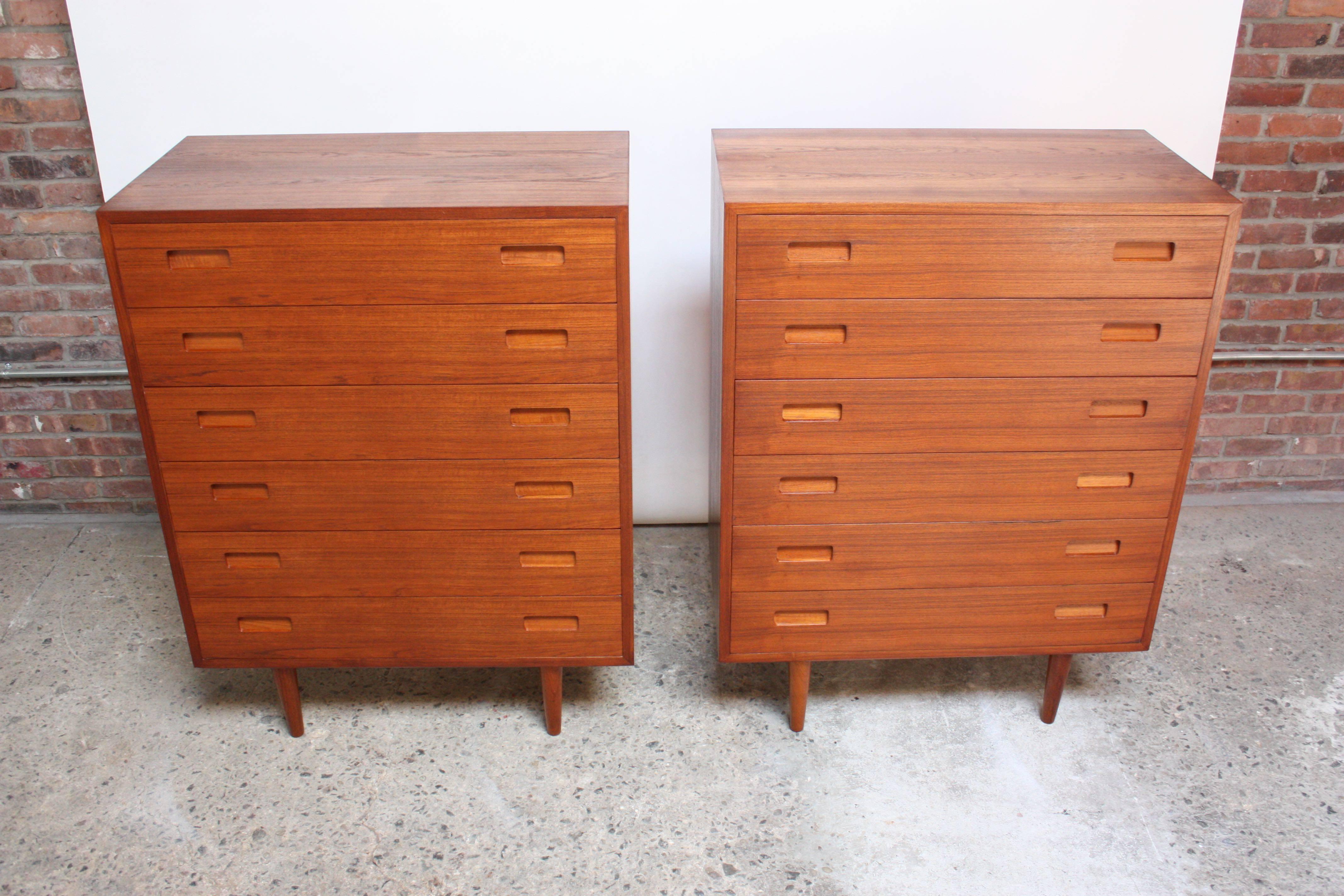 This pair of Poul Hundevad minimal teak 'Bachlelor' chests boasts clean lines and vivid book-matched teak grain. Each drawer (six / chest) has carved, recessed pulls, and the drawers open effortlessly. Chests are supported by solid teak turned
