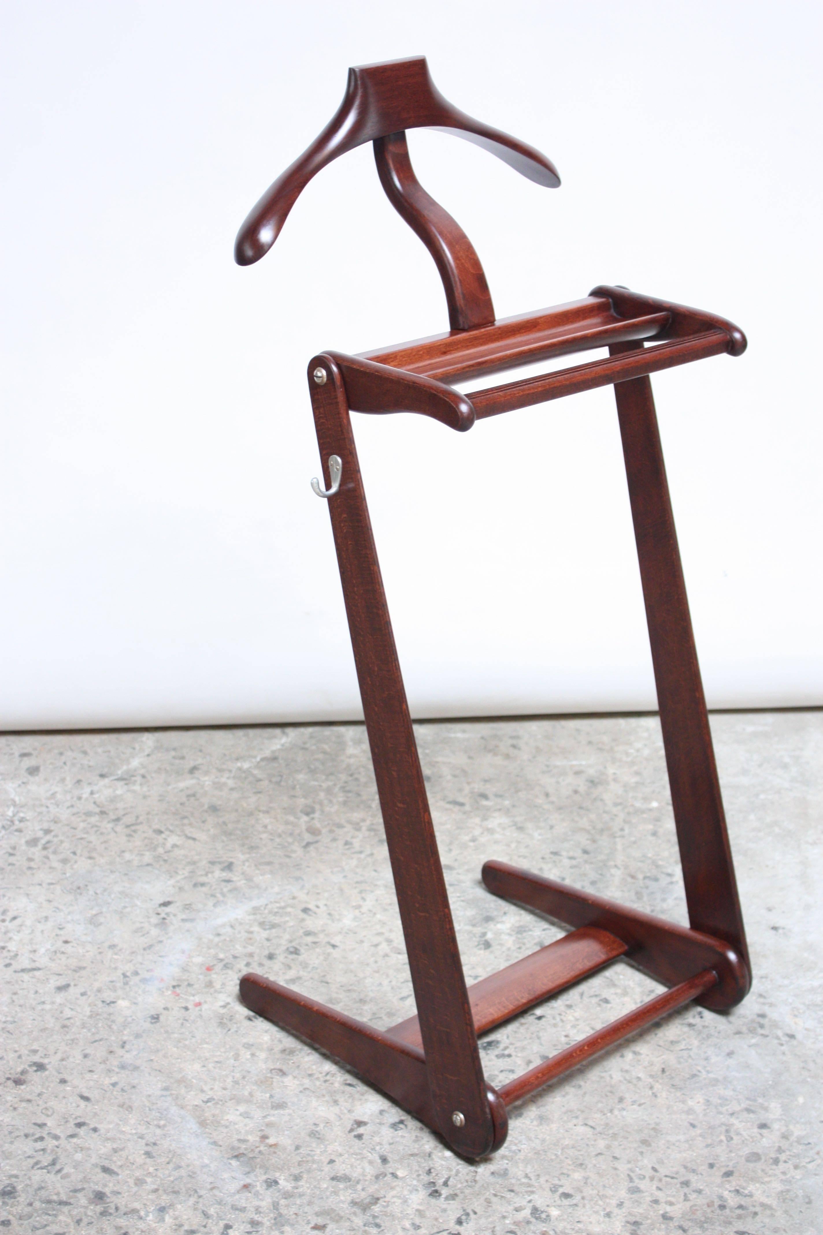 Handsome, sculptural-form mahogany valet with a hanger, double rack on the bottom for shoes, top bar for hanging scarves, ties or pants and an additional aluminium hook on the side. Branded 'Made in Belgium' to the underside, and embossed NYC