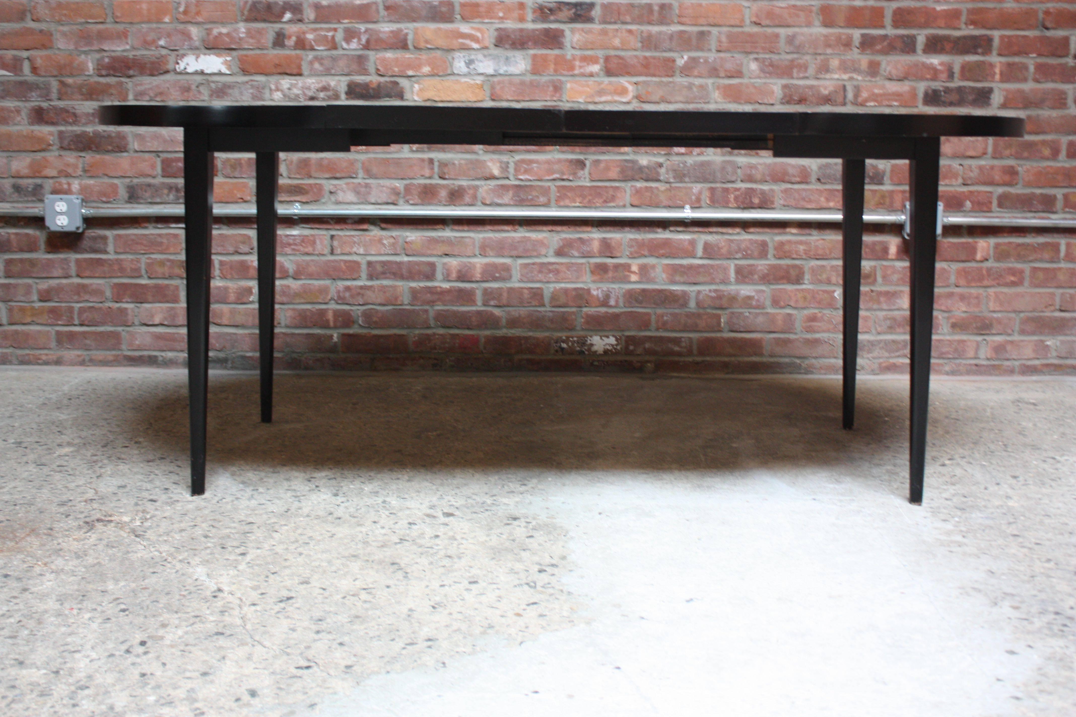 Paul Mccobb designed this ebonized maple dining table for the Winchendon Furniture Company as part of his 'Planner Group' series in the 1950s. Comes with two 15.25