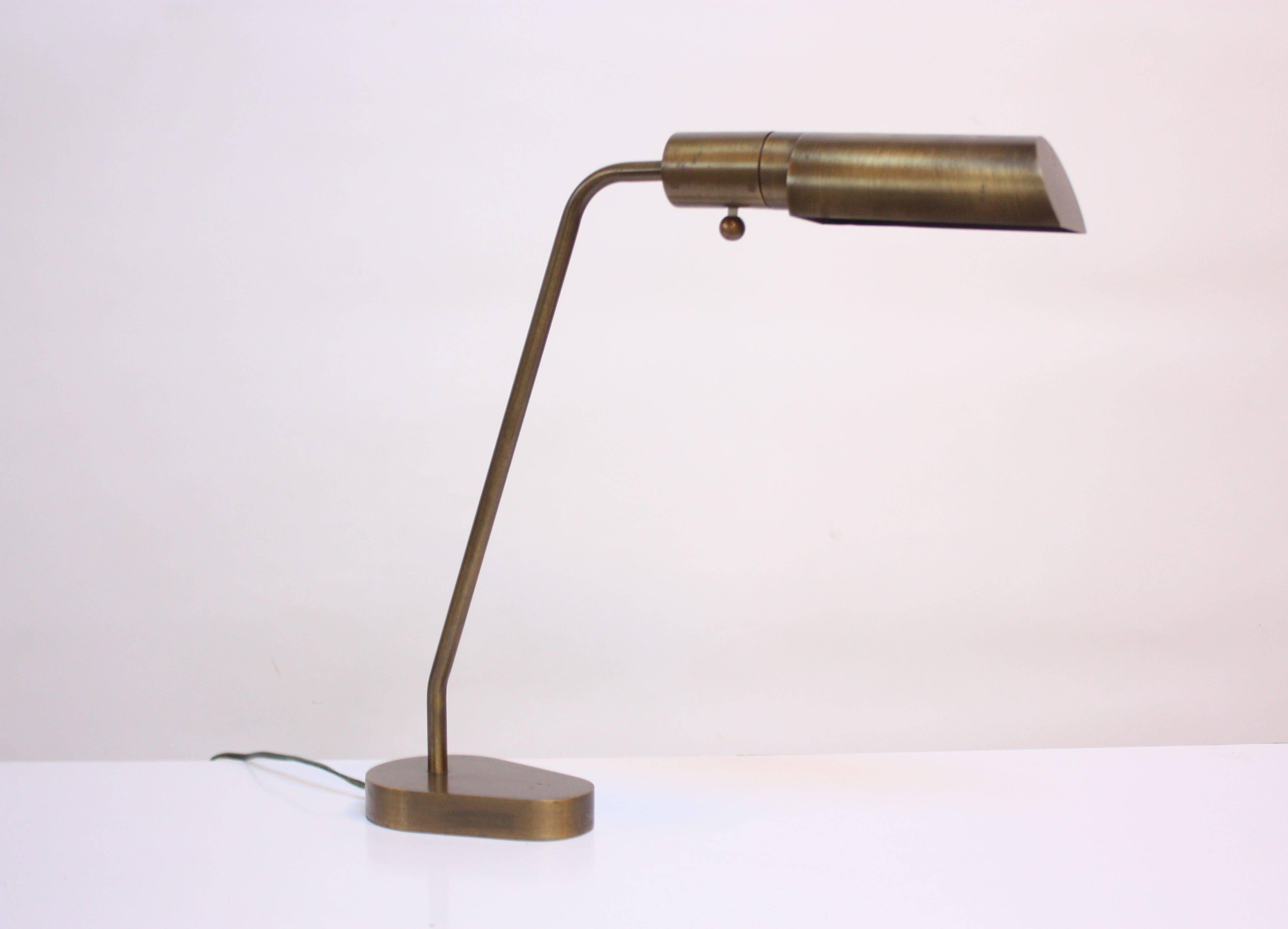 This graceful, articulated table lamp was designed by Chapman in the 1970s combining Industrial and modern design. Comprised entirely of brass this piece also features the signature bronze finish and dimmer 'ball' knob. The shade is fully