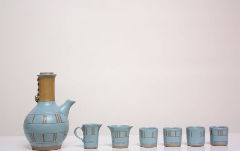 Complete tea set from Gordon and Jane Martz for Marshall Studios in rare sky blue matte glaze with Incised linear decoration throughout. The original leather wrap and cork top are intact on the teapot. This set is pristine; there is no trace that