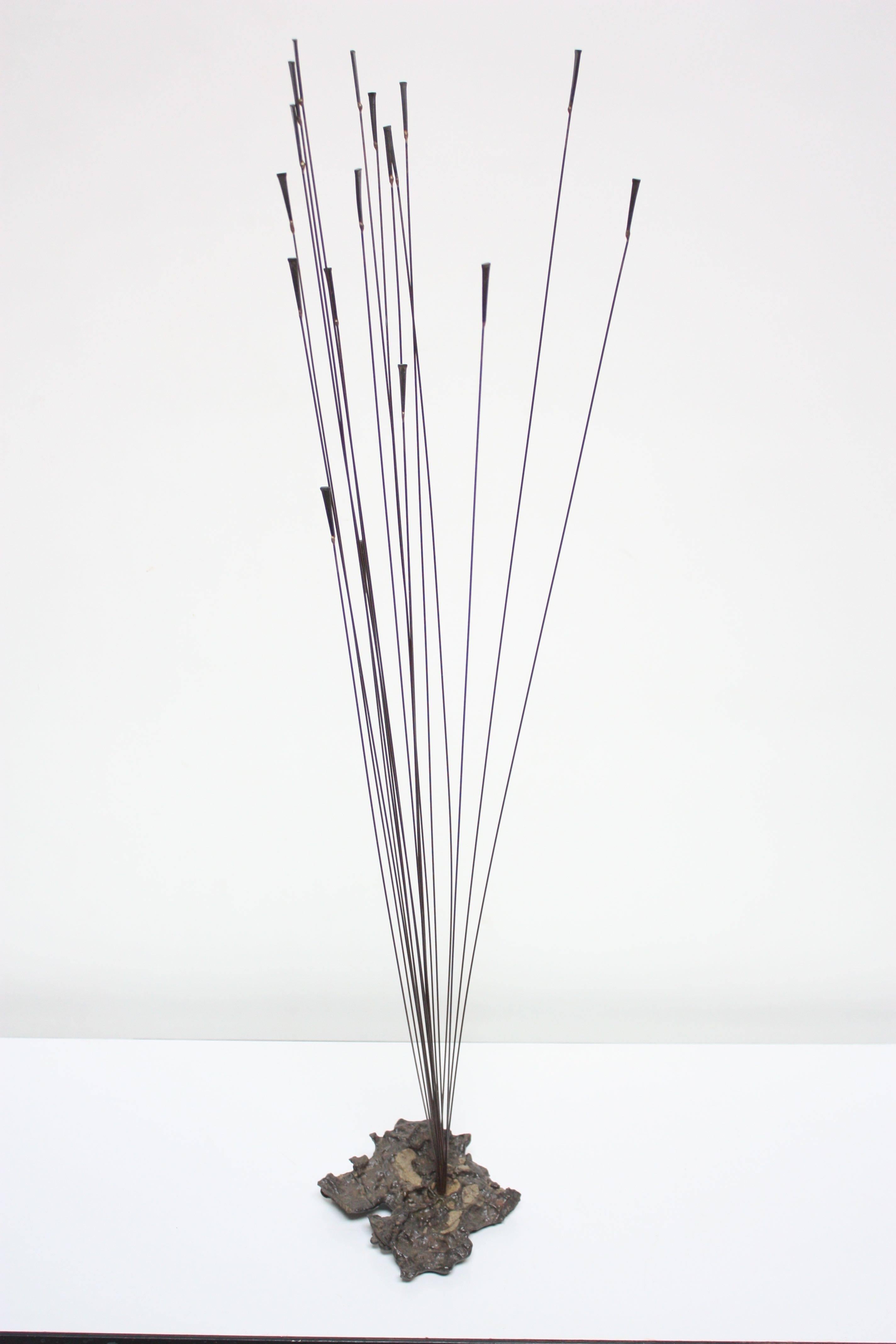 1960s Bowie Brutalist work composed of patinated steel rods and braze welded masonry nails with gilt decoration which fan out to create a free-form / moving sculpture. The cluster of rods is housed in a cast-stone base. 
Base measures: 7.75" L