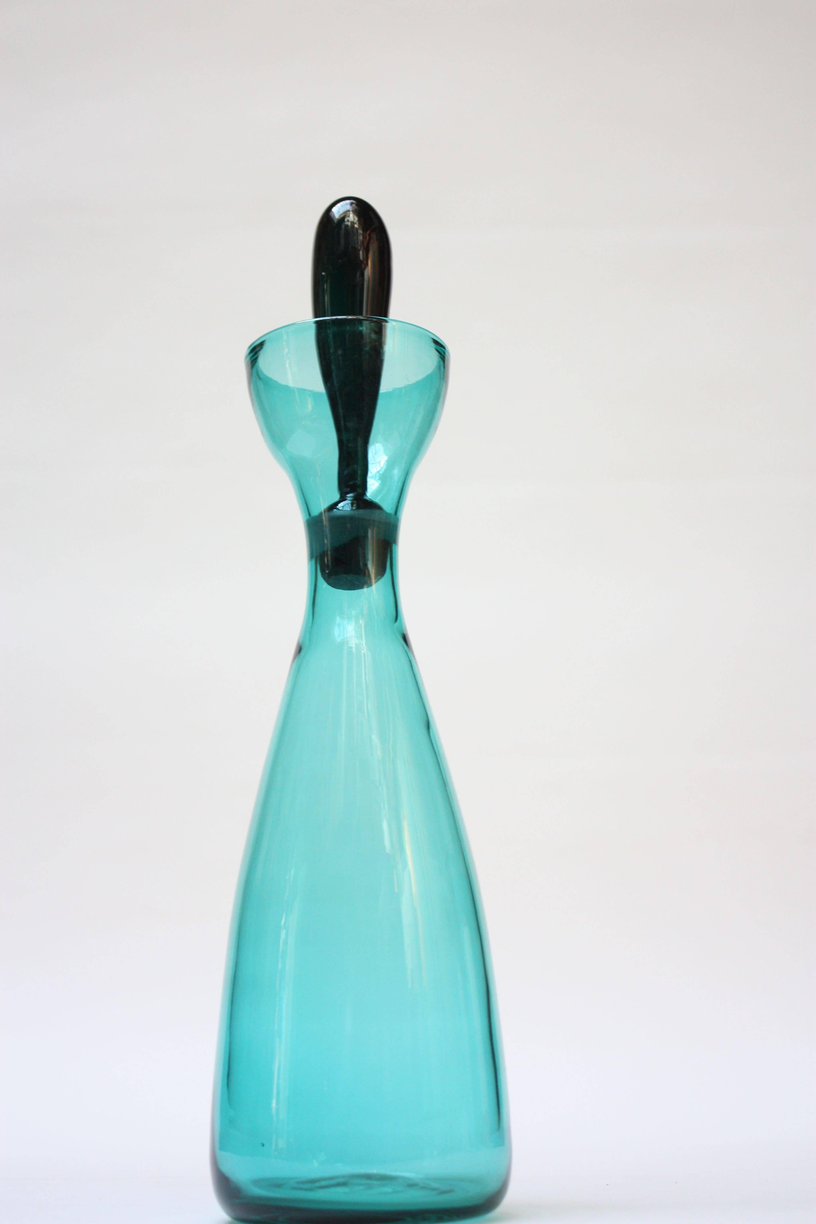 This is a rare example of the Blenko #564 Decanter designed by Wayne Husted in 1956. The teal decanter is offset with its emerald green stopper and creates a nice contrast in color. The piece is in excellent, vintage condition; there is only a