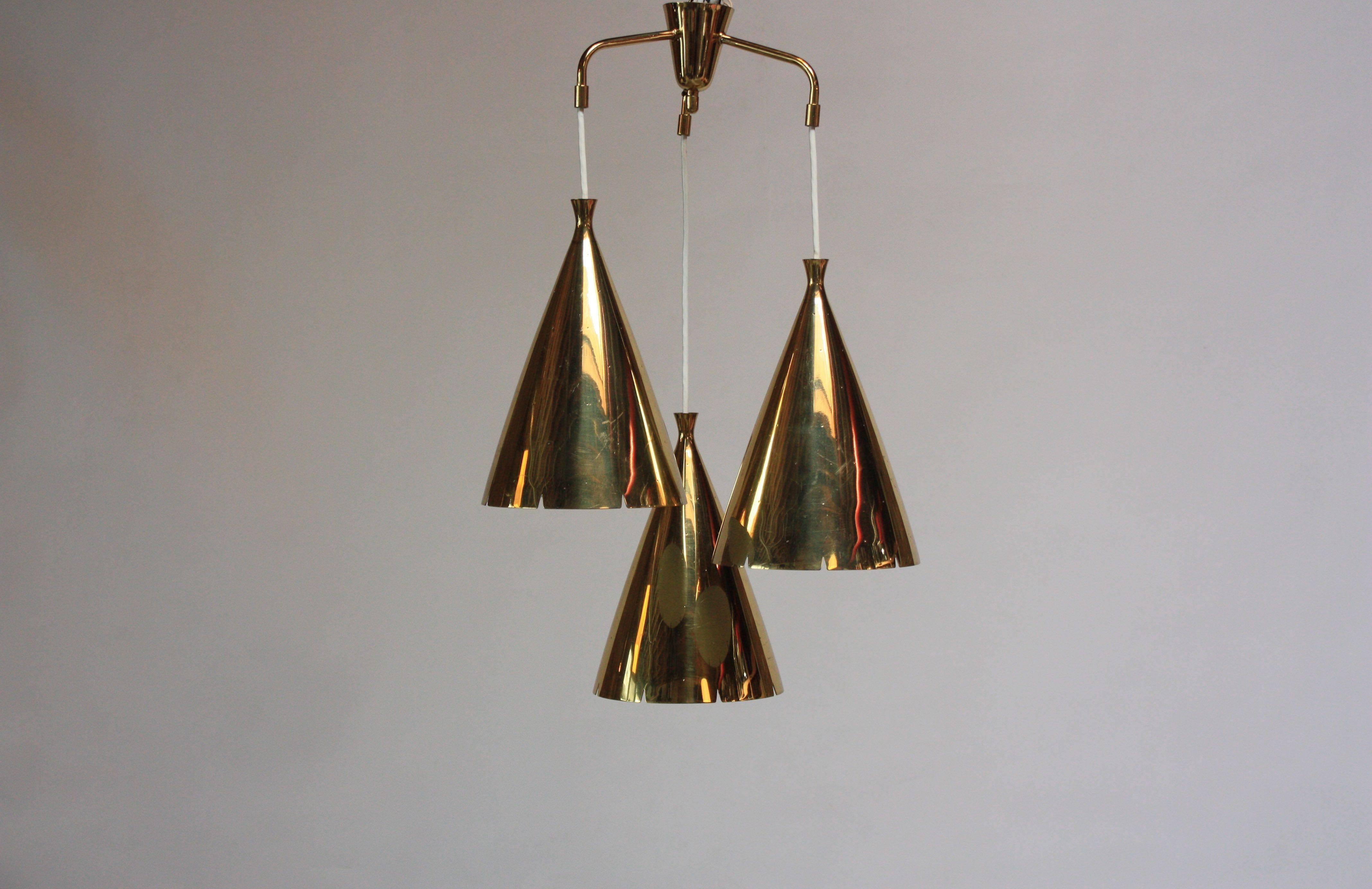 Impressionante lampadario a tre luci in ottone massiccio, anni '50 circa. Composto da tre grandi pendenti in ottone con perforazioni (ogni apparecchio da solo misura 12,25