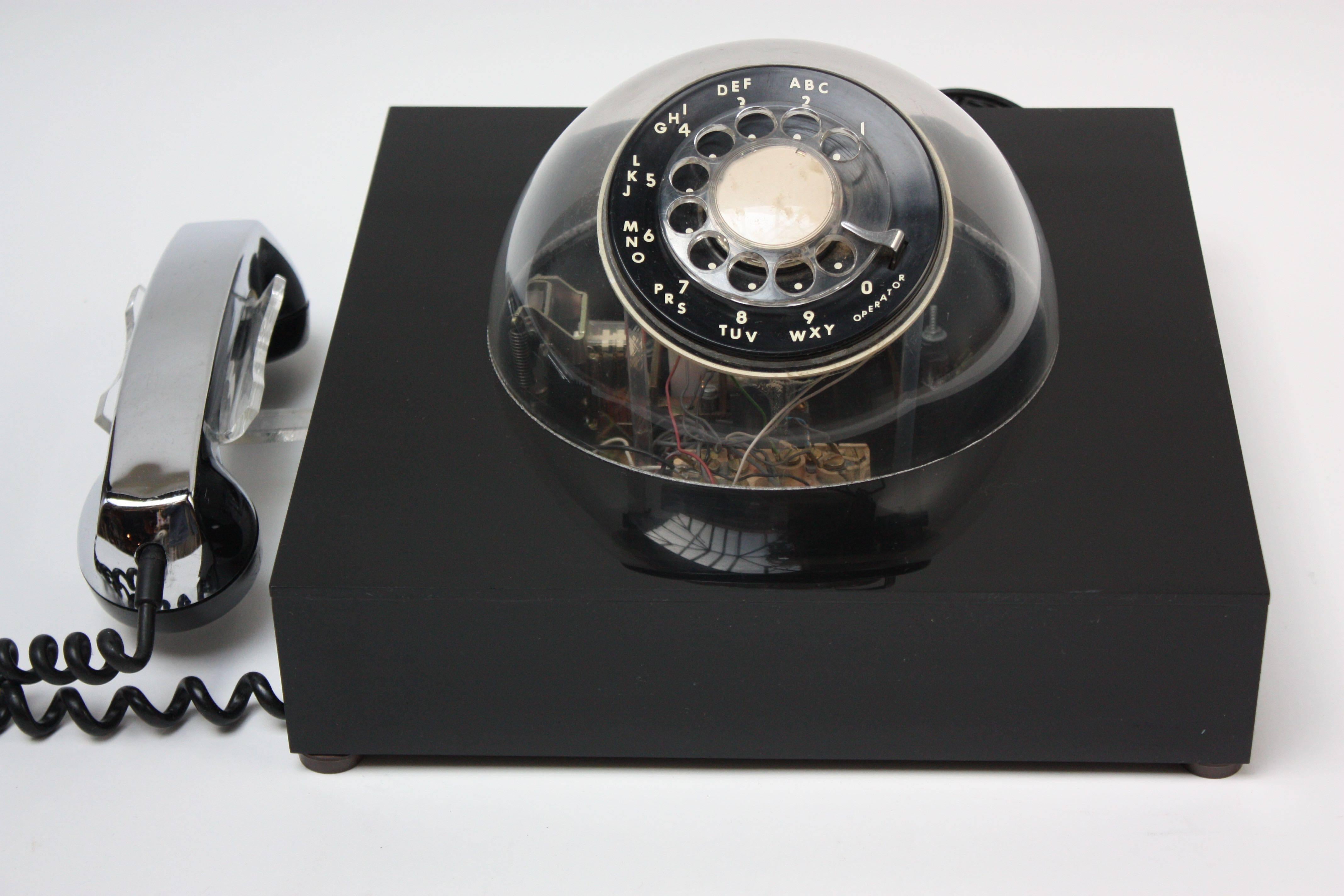 This futuristic Teledome (model #3005) phone was patented and manufactured in 1972 by Teleconcepts and included internals made by Northern Telecom Inc. Chrome-plate handset with black acrylic box and clear plastic dome for accessible view of