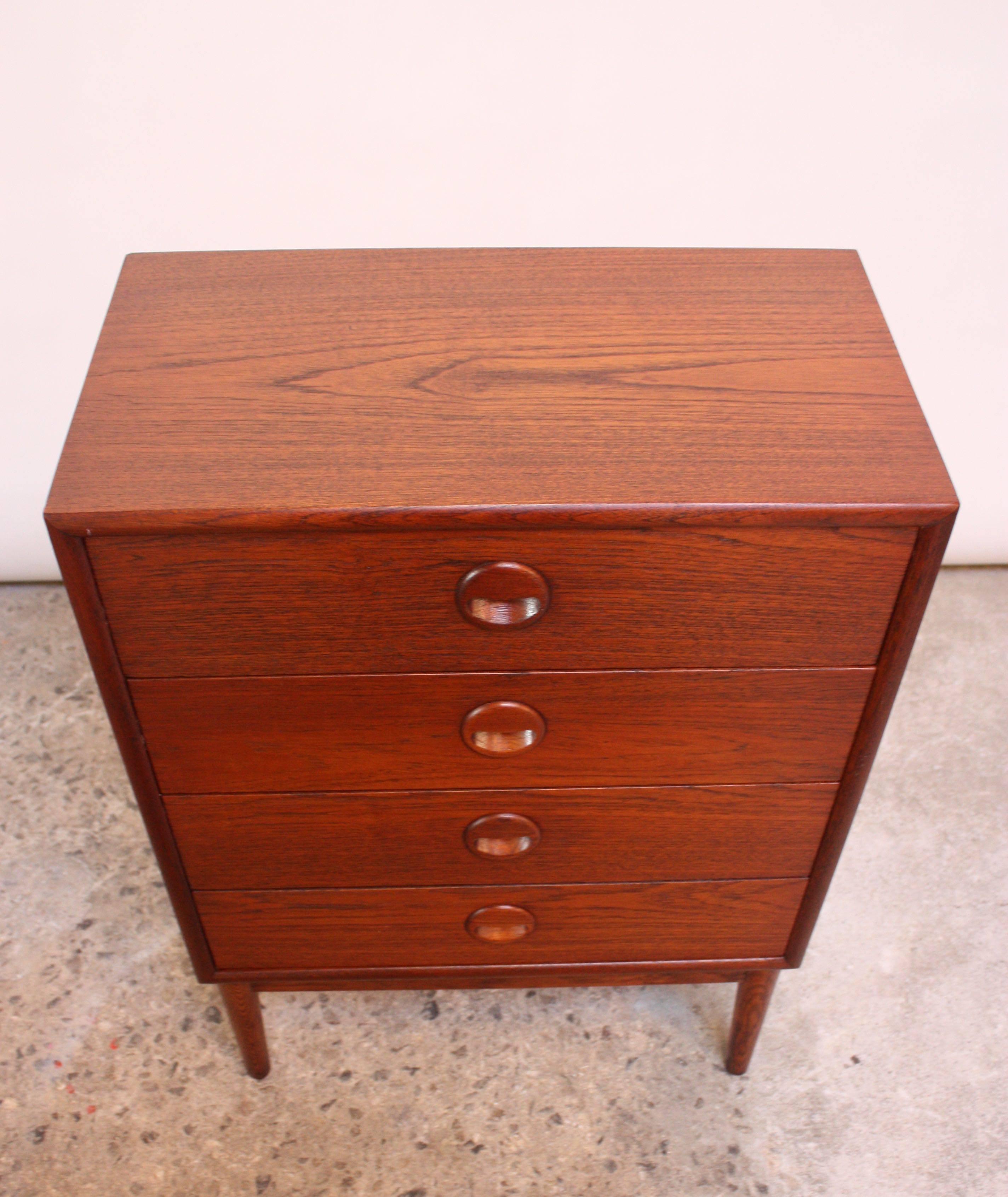 1960s Danish four-drawer teak chest with round eyelid drawer pulls on tapered oak legs.
Diminutive size (21.1