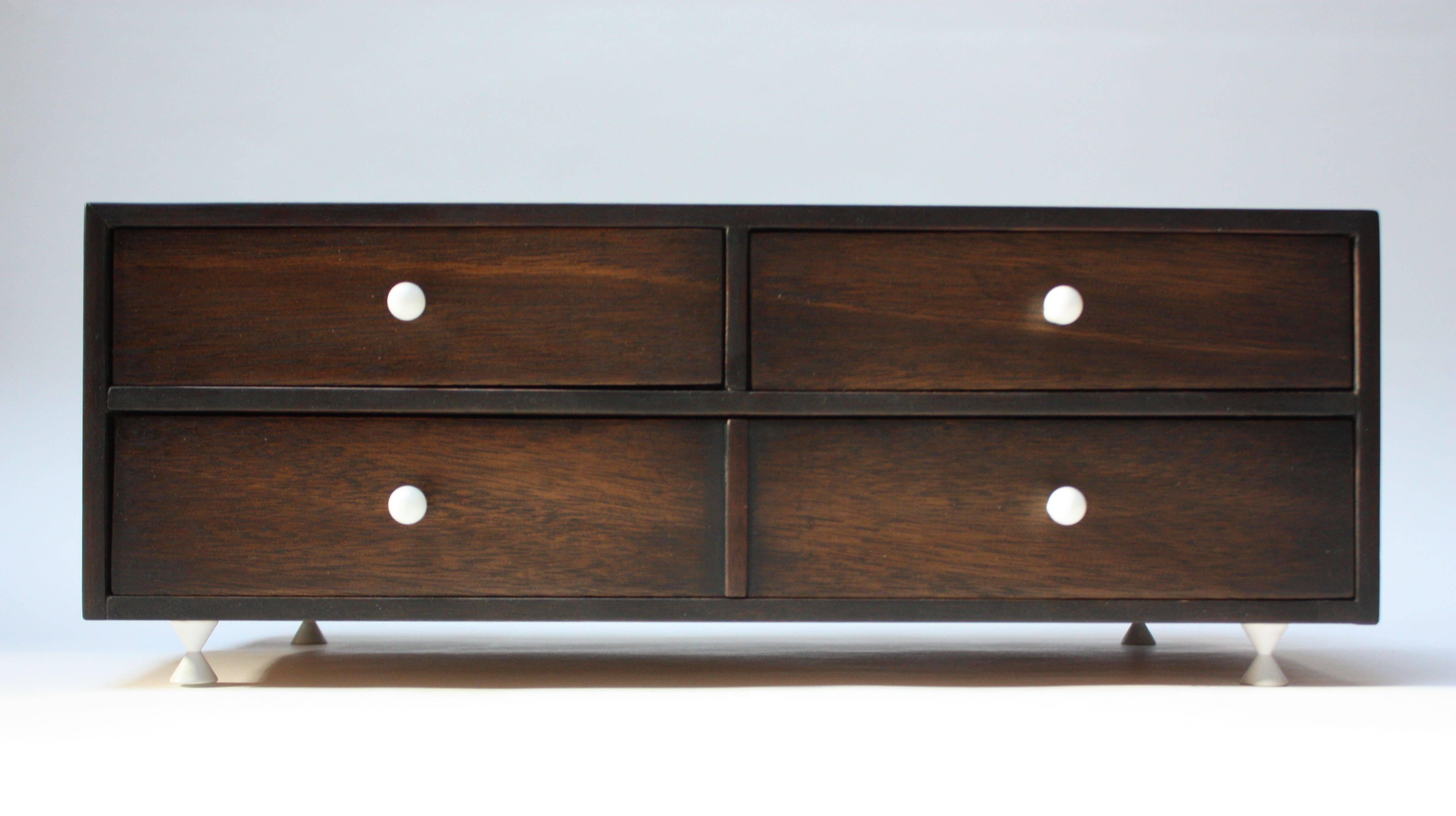 Originally designed in the 1950s by American of Martinsville as the smaller 'chest-on-chest' component to sit atop the corresponding sideboard, this piece can be used to hold smaller linens, napkin rings, and silverware. However, its more practical,