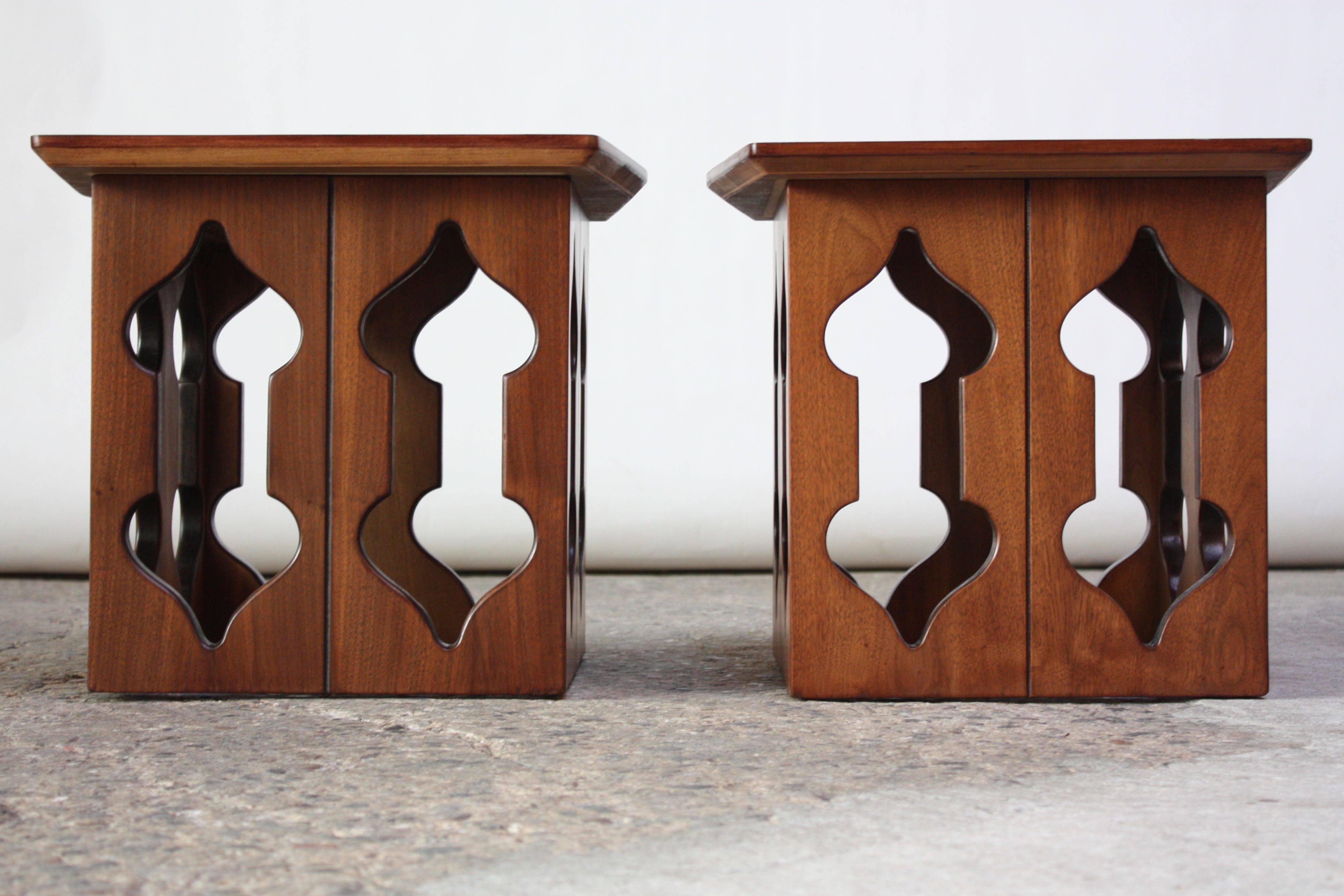 Pair of midcentury American modern walnut end or side tables with Moorish-style carved openings. Unique form and beautiful walnut grain. Newly refinished condition. Originally retailed at Barker Brothers in Los Angeles.