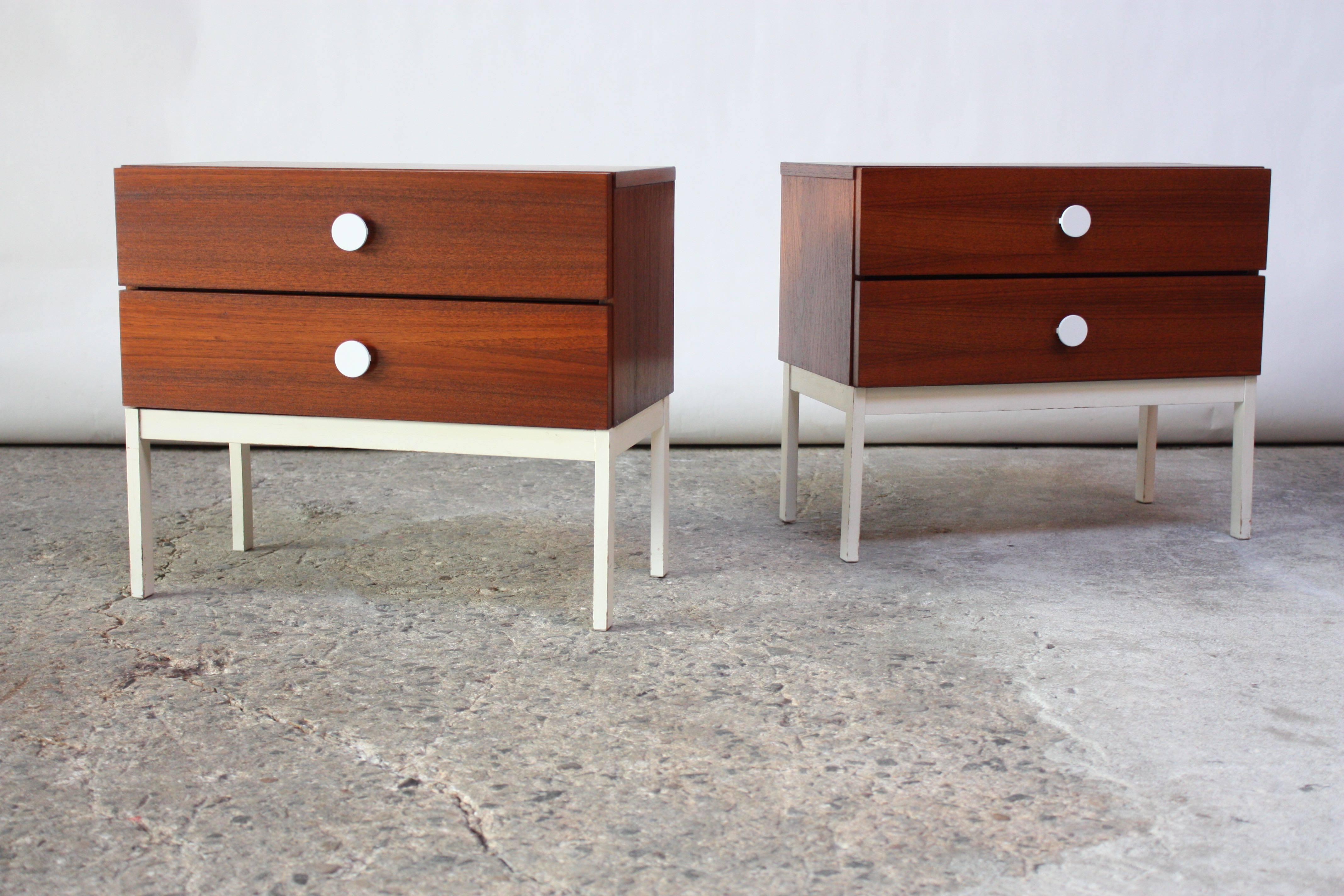 1960s Danish nightstands in teak with original white painted pulls and base. Beautiful contrast of the matte white against the rich color and texture of the teak. Minor paint loss to the base, as pictured. Frame has been refinished. 