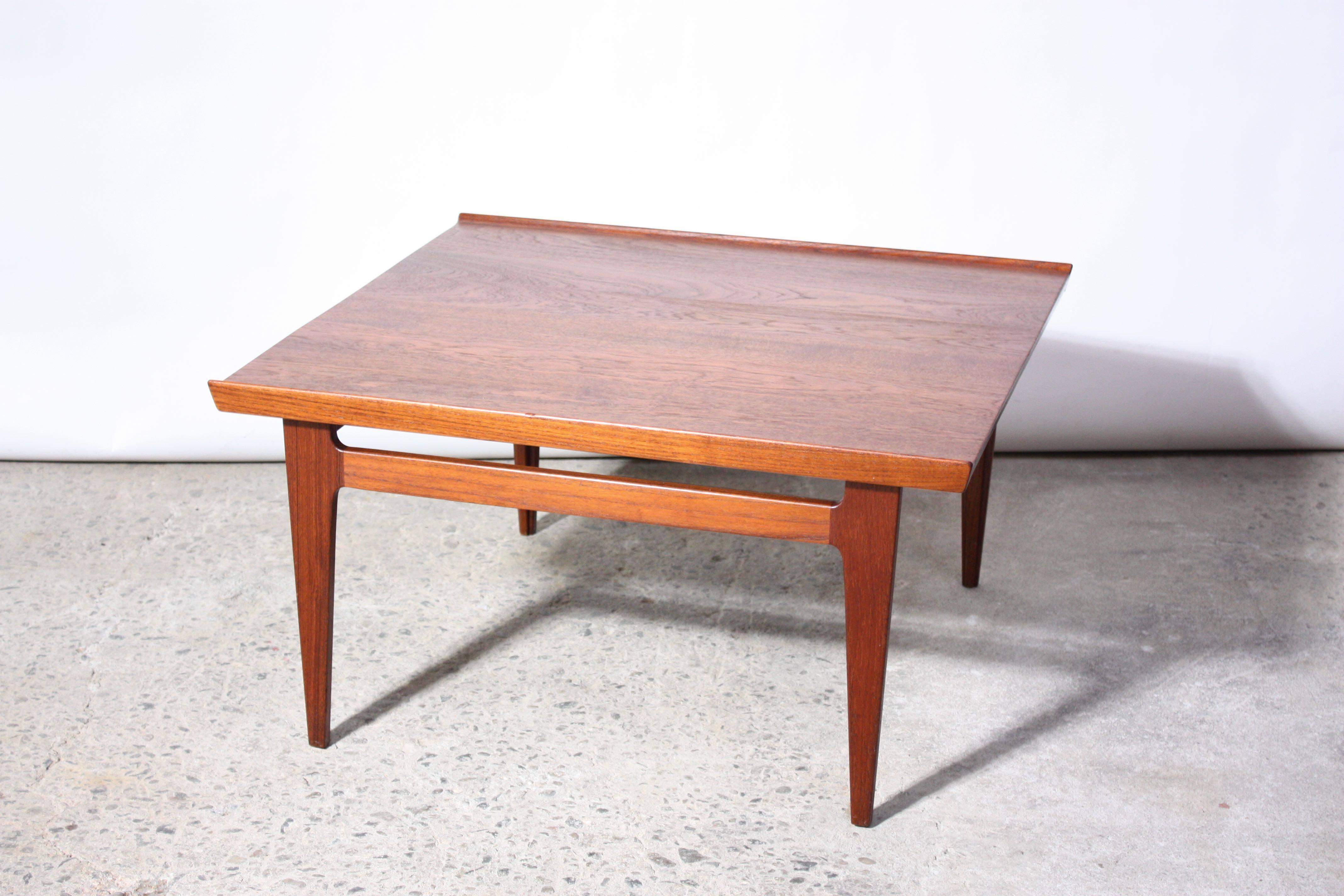 This teak table (not a perfect square, but close to) was designed in the 1950s by Finn Juhl for France and Daverkosen (pre-France and Son's 1960s version). It has been expertly restored without compromising the integrity of the color or texture of