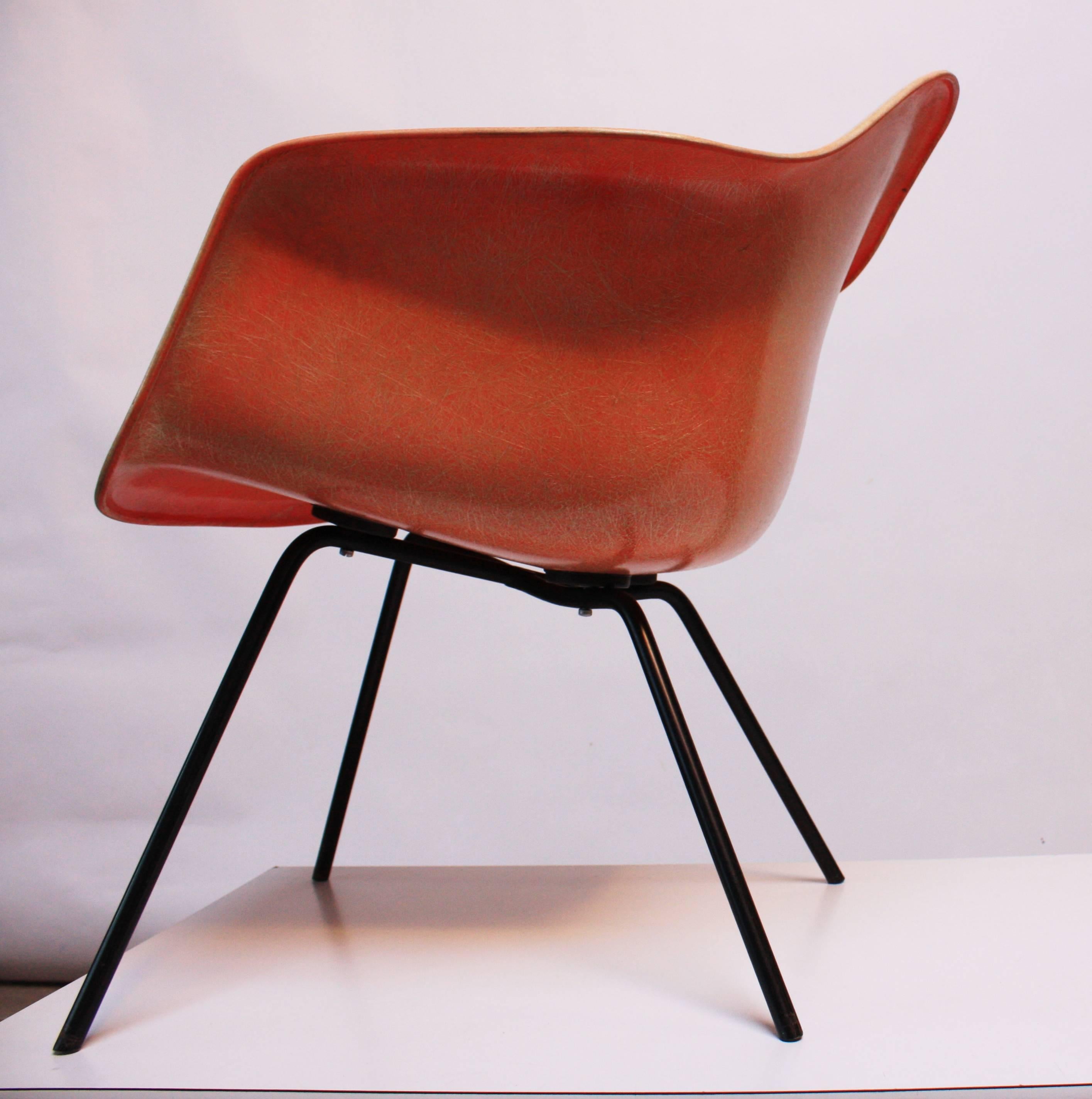 This early production Eames Rope Edge Chair is the lounge X-base version. There are no cracks or chips to the salmon fiberglass armshell, and the original shock mounts and screws are sound and intact. The underside of the seat retains its Zenith