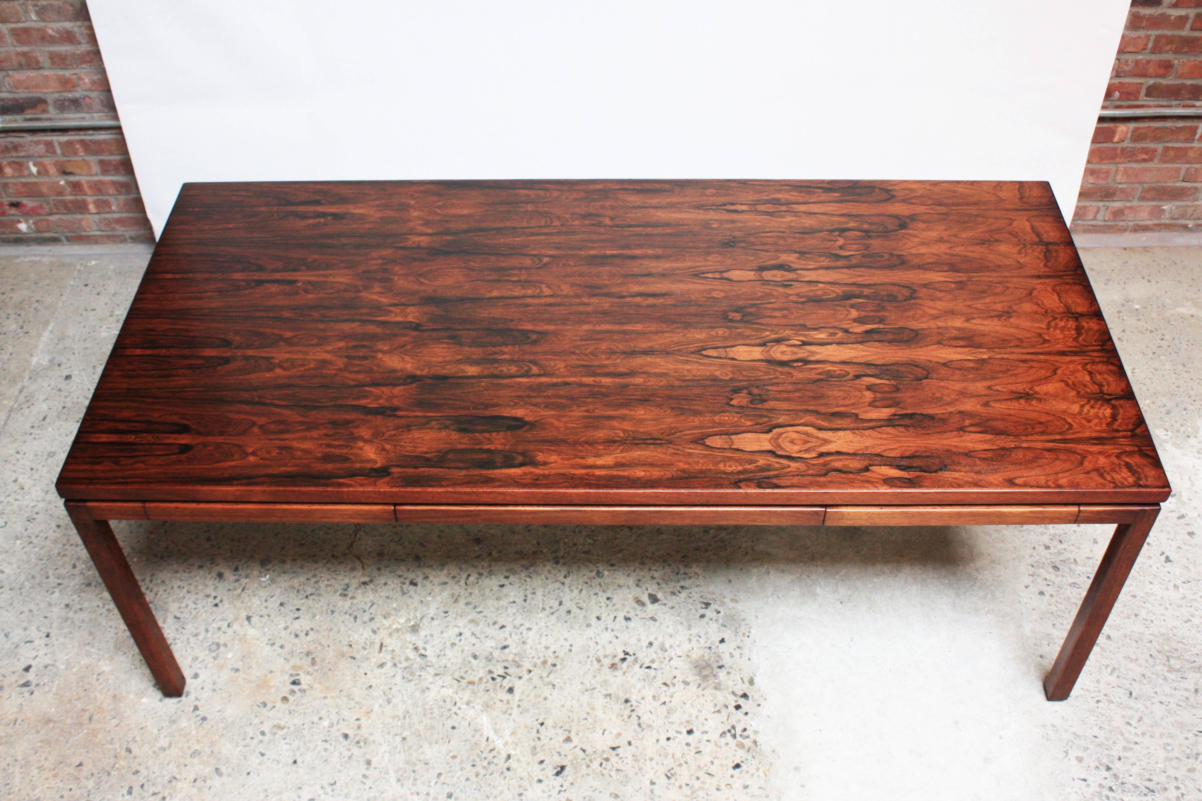 This exquisite desk, likely custom-made given its atypical proportions, is comprised of a rosewood top offset by a combination walnut legs and mahogany trim. This spacious surface is ample room for two to work side-by-side; each side equipped with