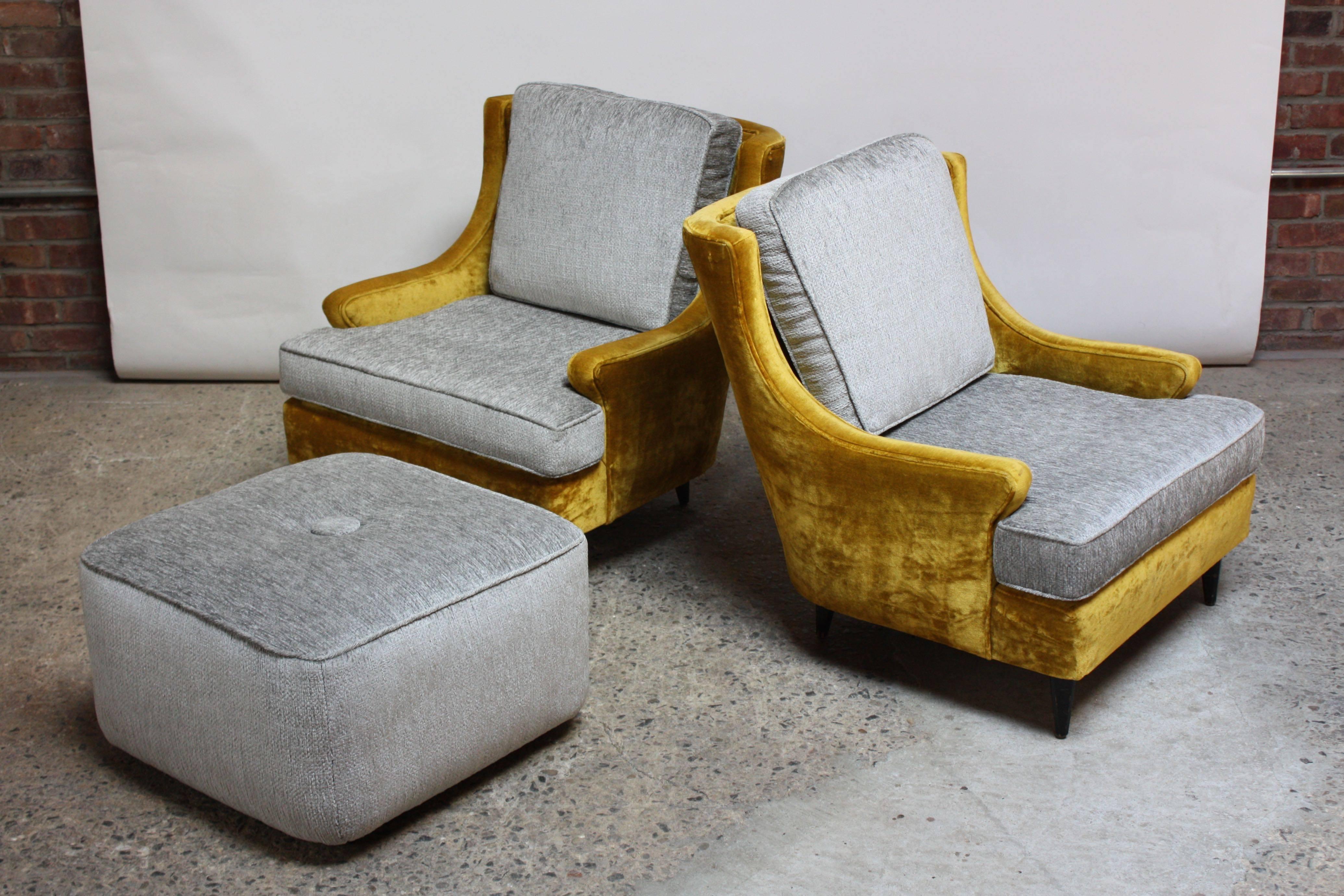 This luxurious pair of low 1950s lounge chairs retains the original mustard velvet shell. The cushions have been redone in a steel grey chenille, and the foam has been replaced. The feet retain their original ebony stain. The matching oversized