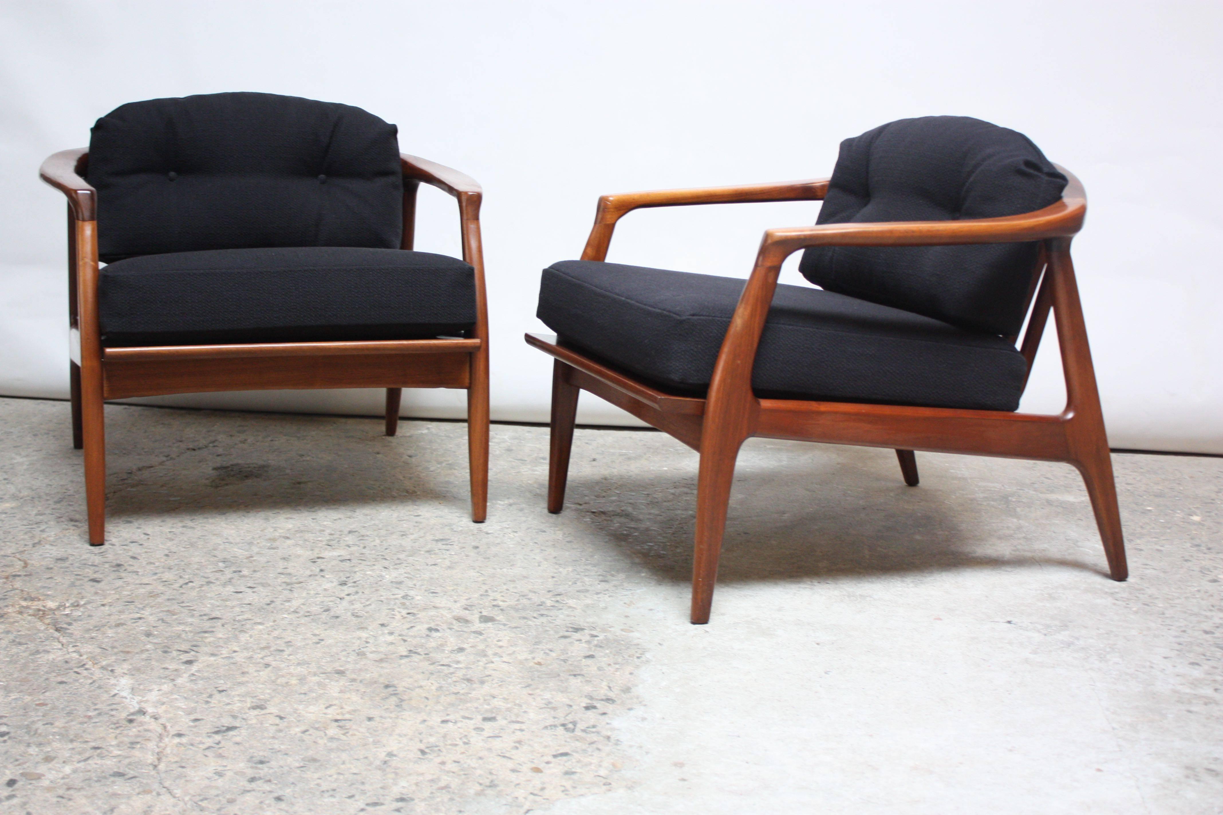 These Milo Baughman armchairs feature dramatic, clean lines. The exaggerated, slanted legs are nicely contrasted by a curved back with simple stat supports.   
Thayer Coggin fabric tags are intact on both chairs. 
The fabric is a black tweed, and