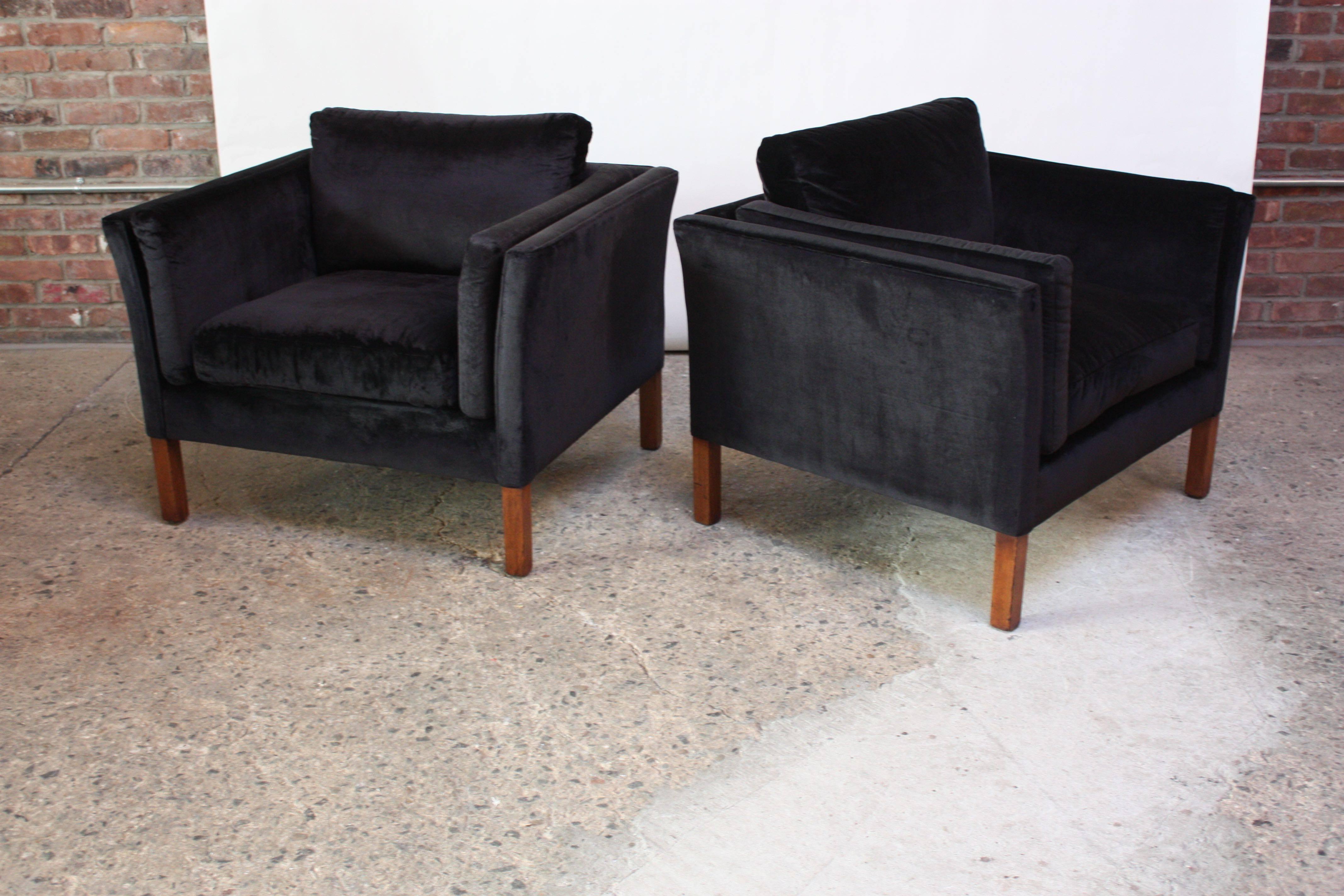 Plush pair of 1970s Danish modern lounge chairs by Mogens Hansen in black velvet with stained beech wood feet. Additional velvet cushions (one on each side) nestle into the curvature of the frames for added comfort / support. Velvet and foam are