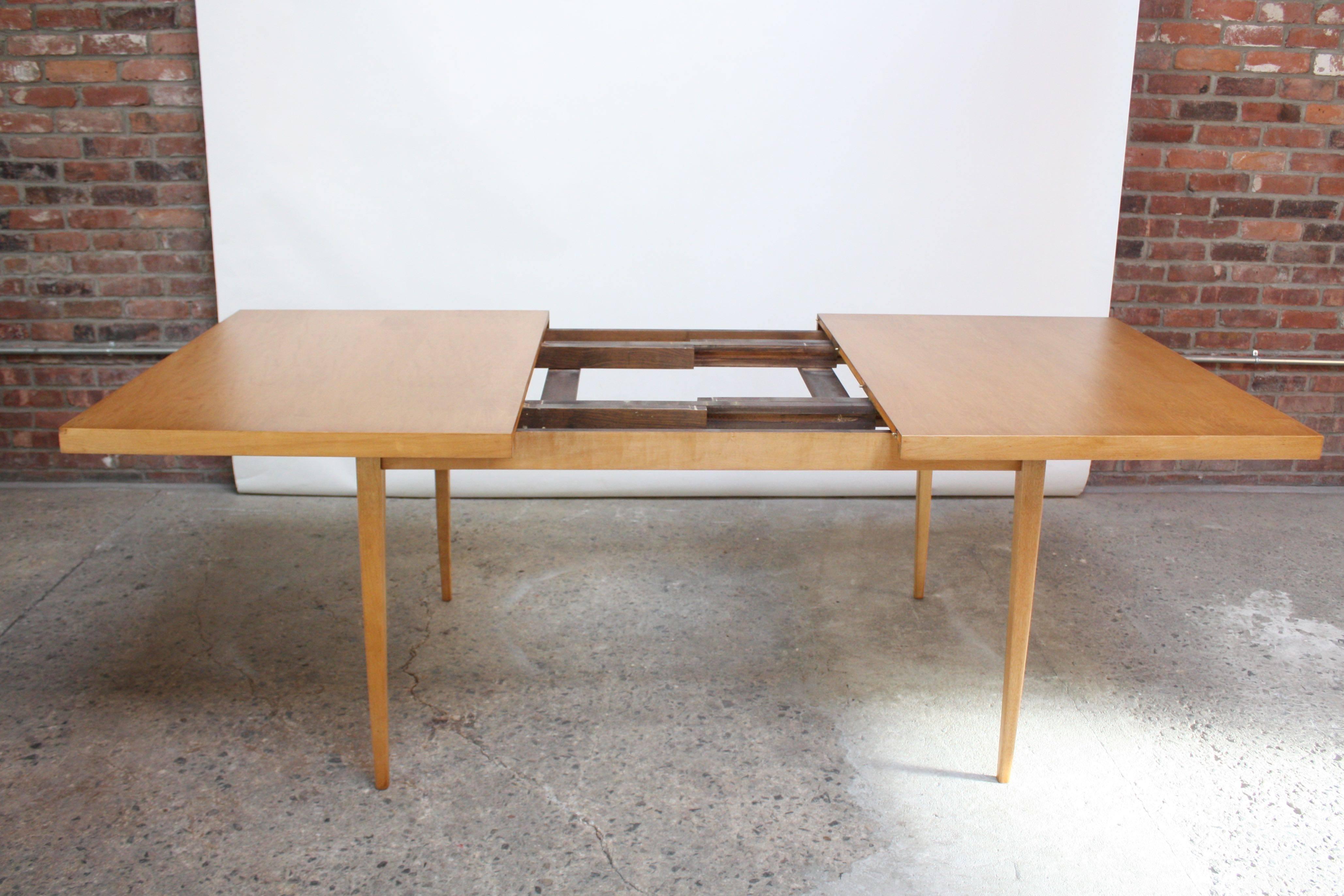 This minimal maple dining table was designed in the 1950s by Paul McCobb as part of his 'Planner Group' for the Winchendon Furniture Company. The table without leaves is 60