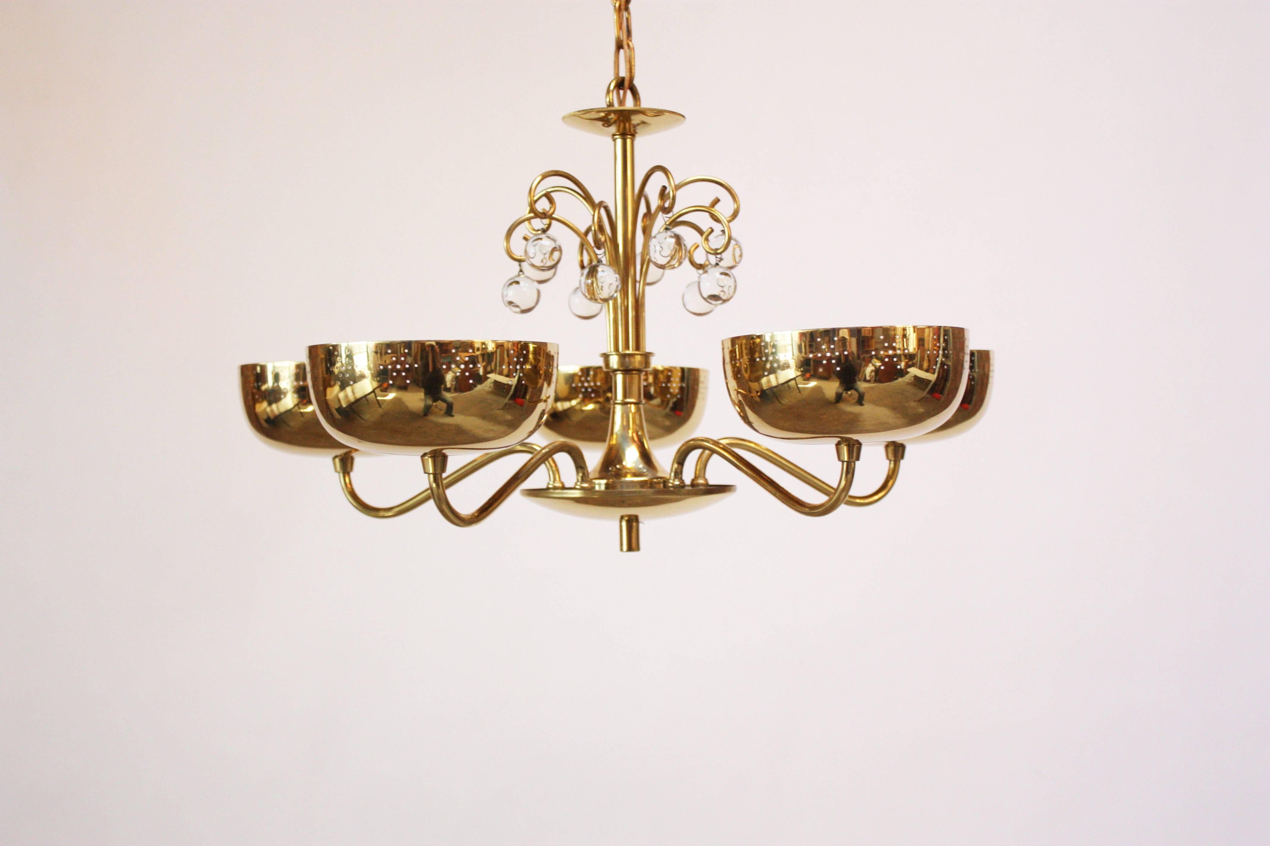 Midcentury brass chandelier with five perforated shades with white painted interiors. Perforation is a 'star' pattern. Fixture is adorned with decorative glass beads and includes the brass canopy.
Measure: Height from the brass loop to the bottom