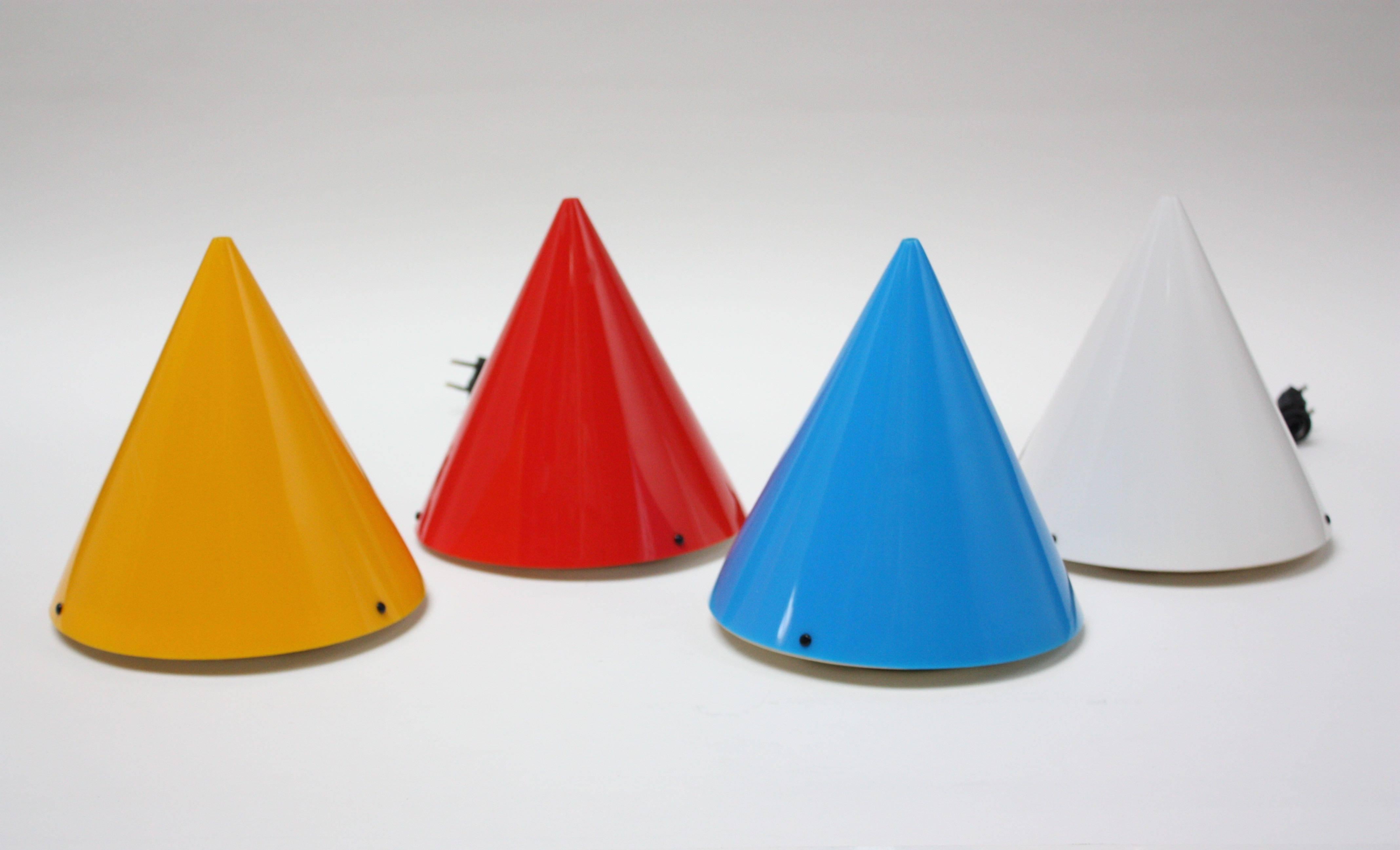 These four conical table or wall-mounted lights in blue, red, yellow and white were designed in 1995 by Verner Panton and produced by the company, Polythema, known for their work in acrylics. Three circular black screws mount each 'cone' to the