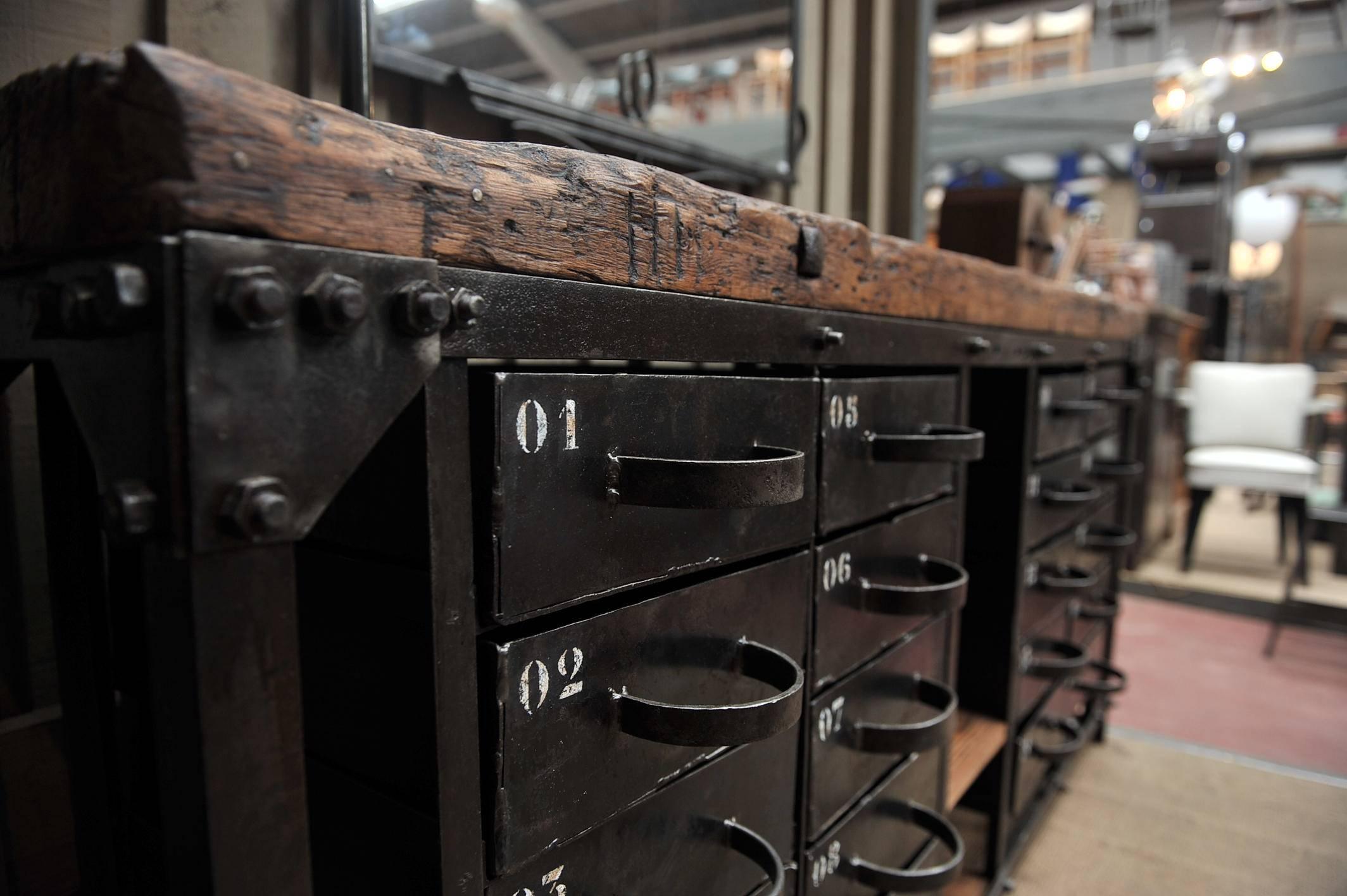 Unusual 20 drawer polished iron French factory industrial workbench with compartments and original big Pine top wax finish, circa 1920s.