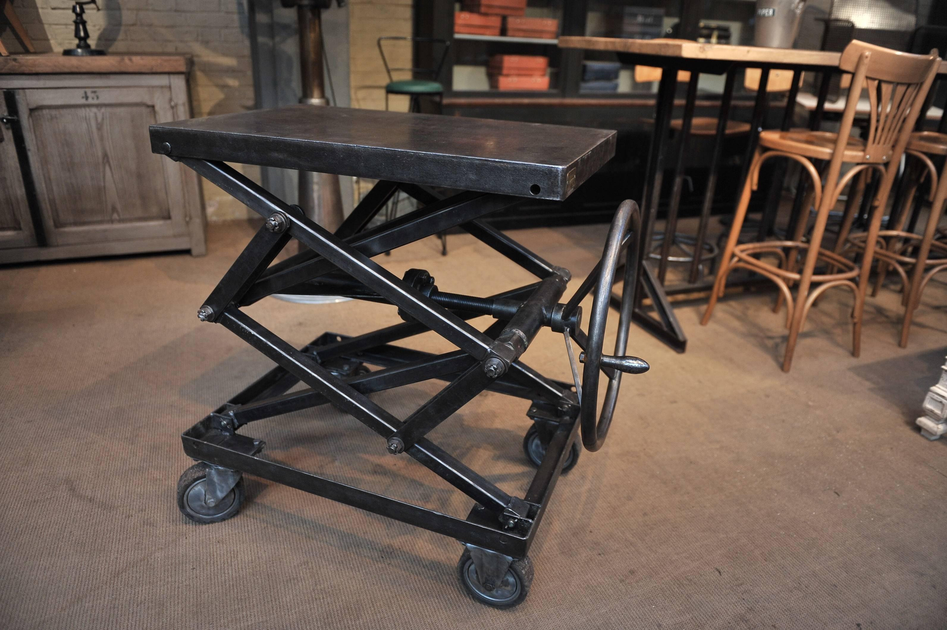 French factory 1930s polished steel rising table Height about 55 to 110 cm.
 Original steering wheel works very well.
Those rising where made for mechanical work shop to carry very heavy load very easily. Top part is 80 x 50 cm.

 