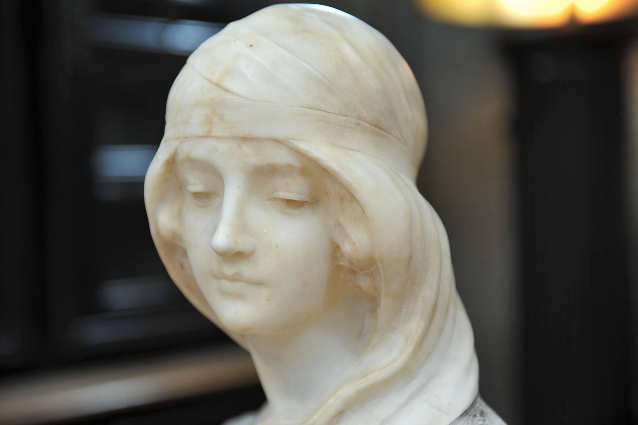 Woman bust sculpture carved in alabaster, on a grey veined marble.
 Signed on the back: Gugielmo Pugi (1850-1915).