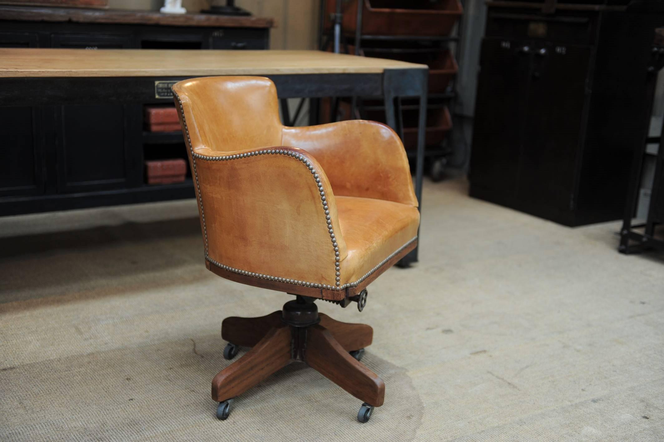 Mahogany base with back adjustable system base French swivel desk armchair on wheels. Original hobnails and leather in rare excellent condition. Very stabile.
 