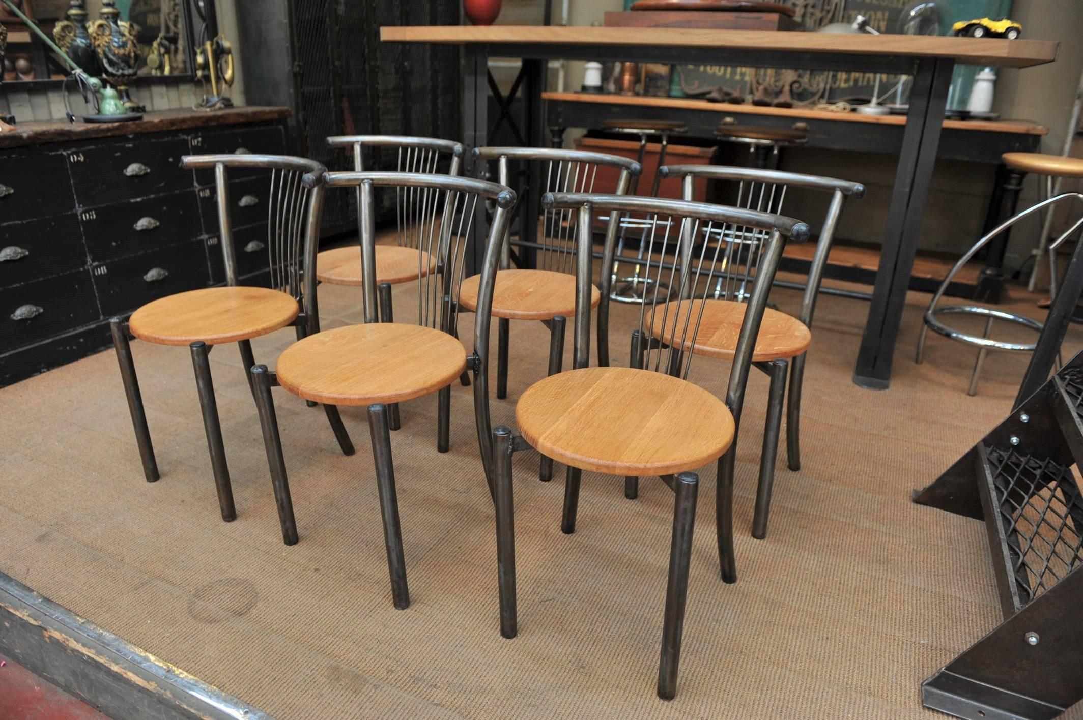 Set of six design iron chairs 1950 new solid oak seats. Measures: Diameter 38 cm.
