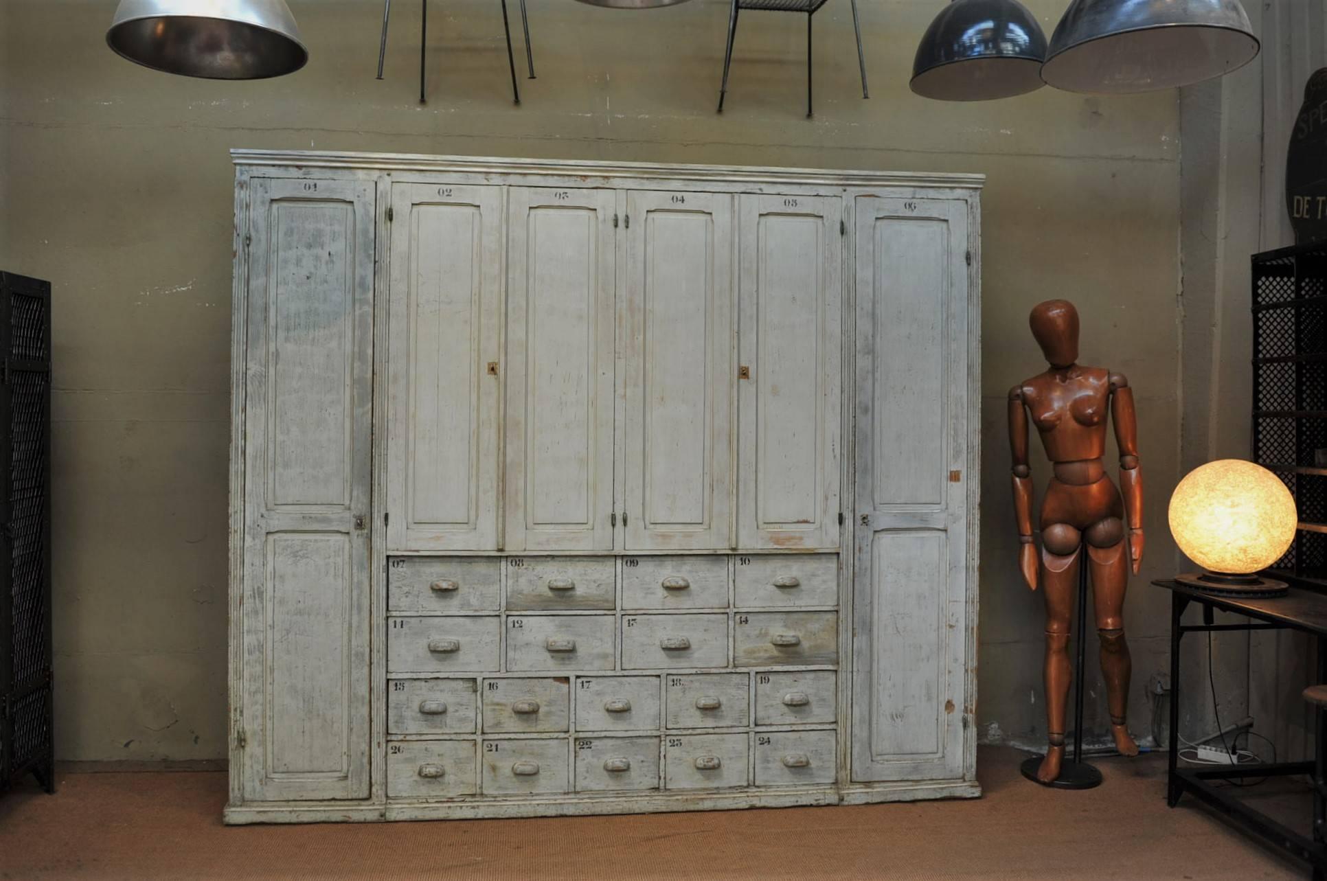 Multi drawer and six doors pine painted cabinet from north of France textile factory, original light grey cleaned and waxed patina, circa 1920.