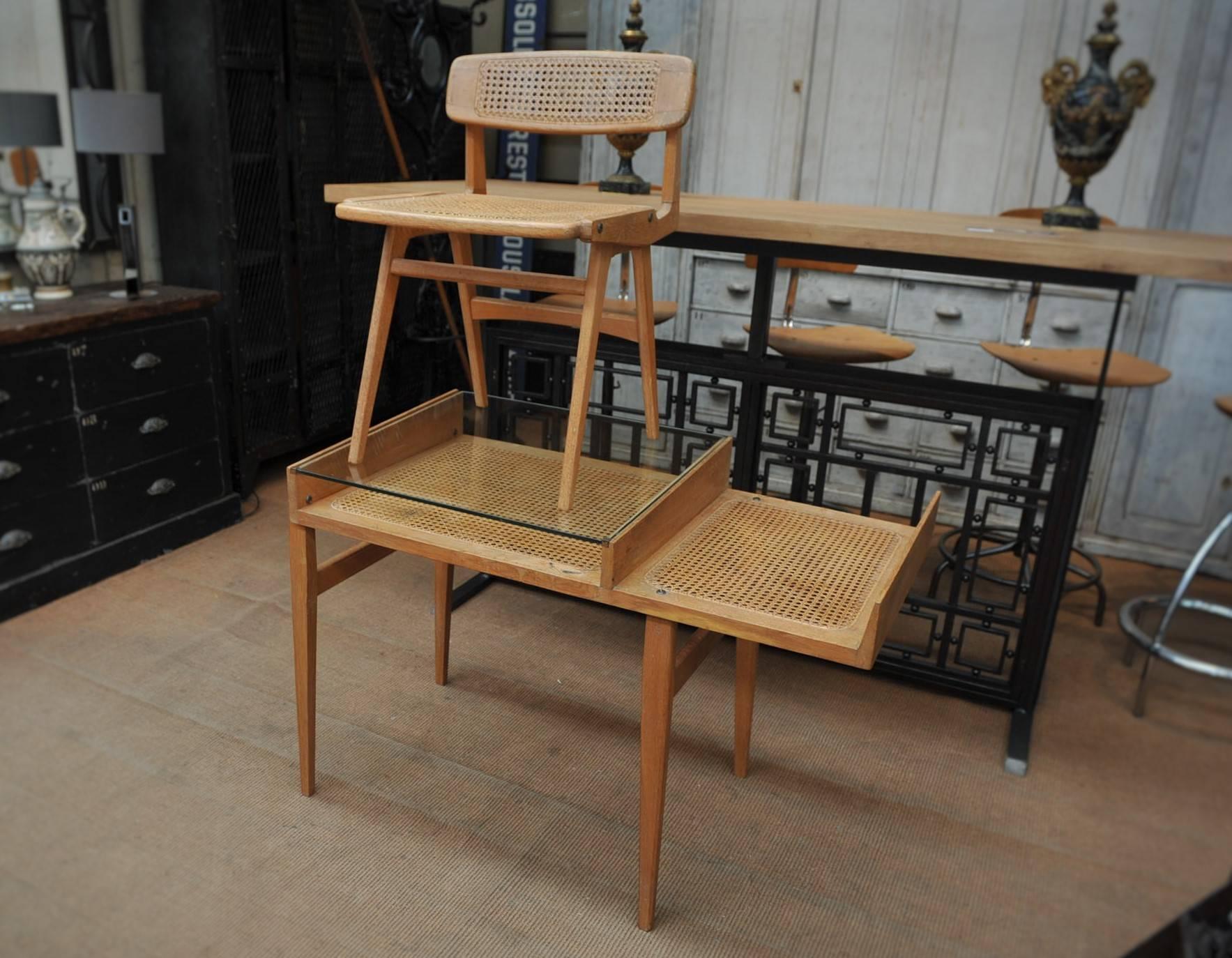 Rare French oak and caned top and removable original security glass desk with it's chair caned back and seat by Roger Landault, circa 1950.
Very stable and excellent condition.
 Measures: Chair: 45 x 45 x H 70 cm. Height seat 46 cm.
