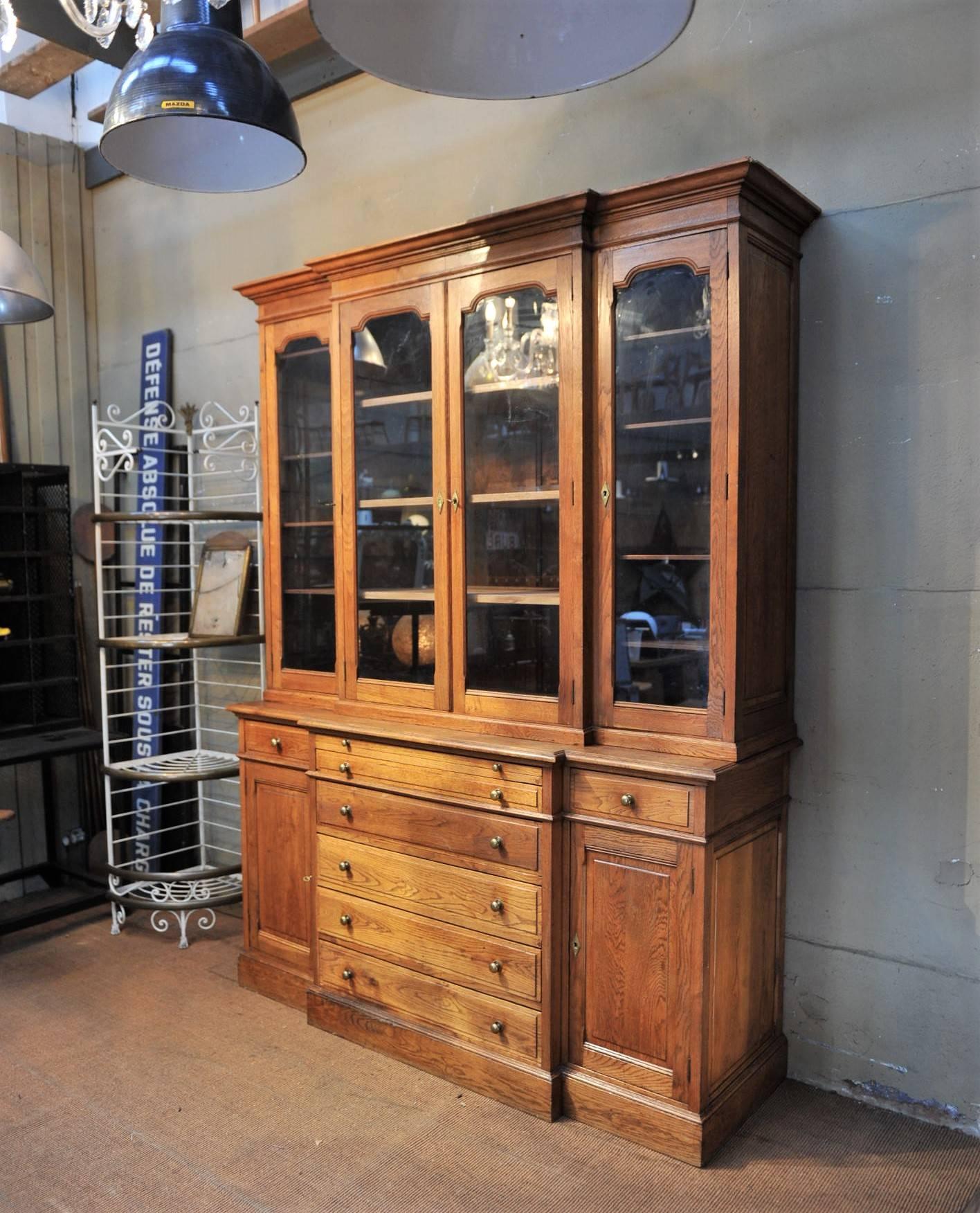 Large solid oak French bookcase two doors, six drawers and two sliding working shelves, circa 1900.