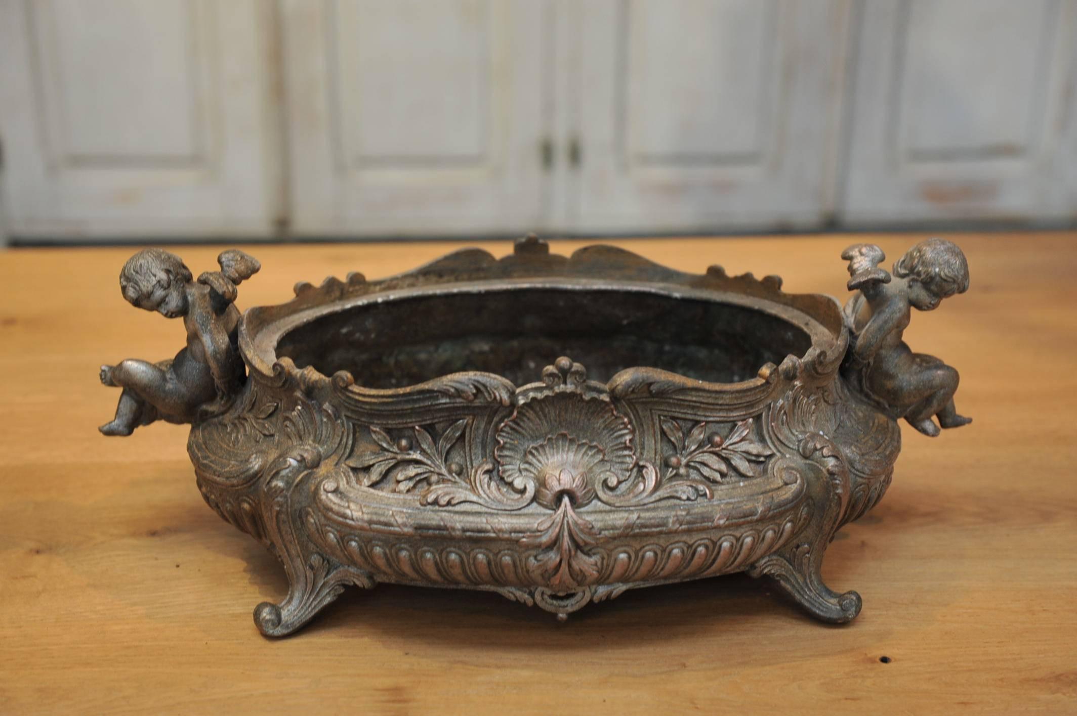 French Louis XV style metal jardinière urn planter with two angels and large Louis XV typical shell on each sides, circa 1900.

