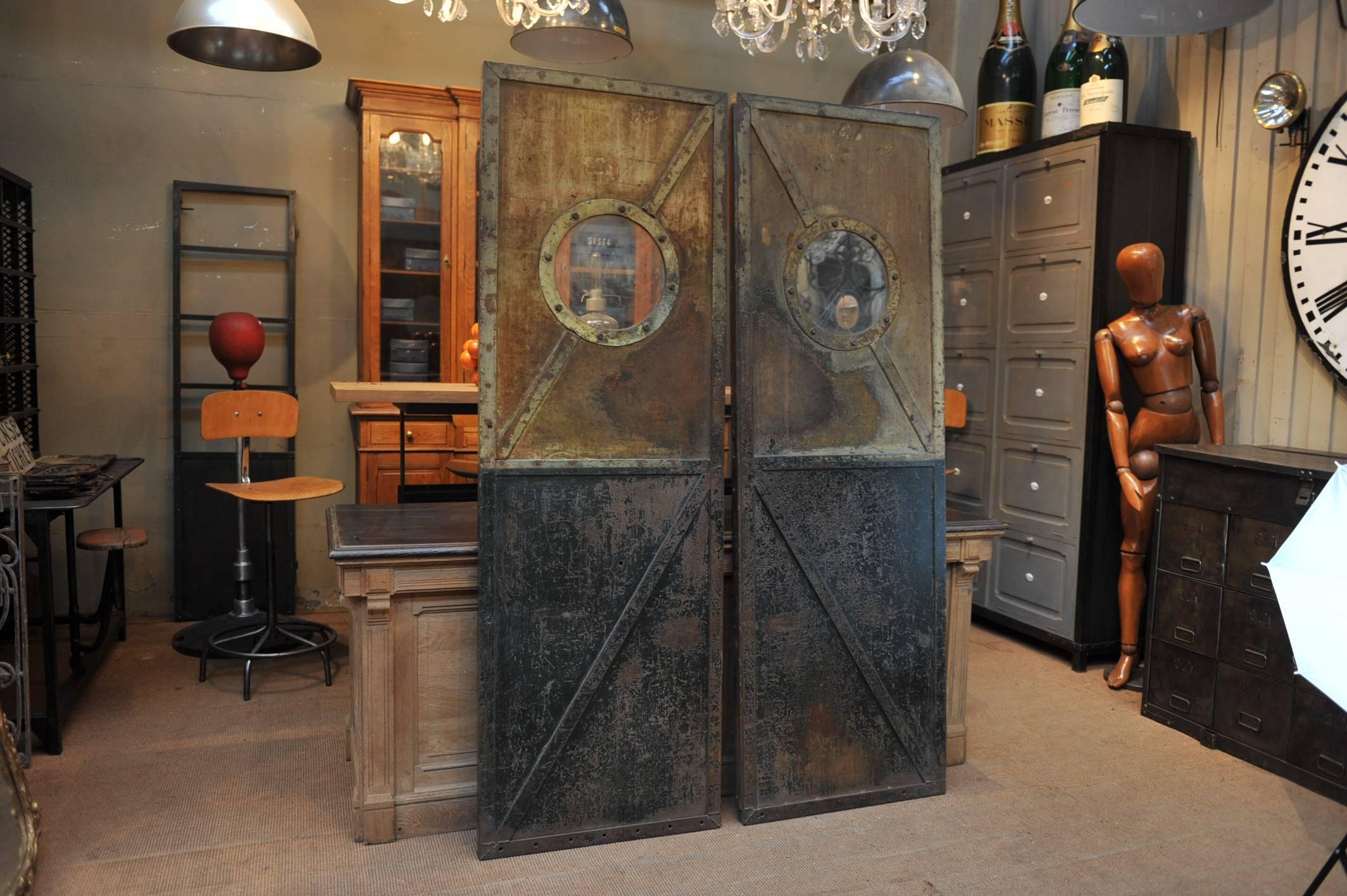 French factory riveted iron pair of doors, 1920s. Original patina waxed finish.
Total width 134 cm, weight 50 kg each.
     