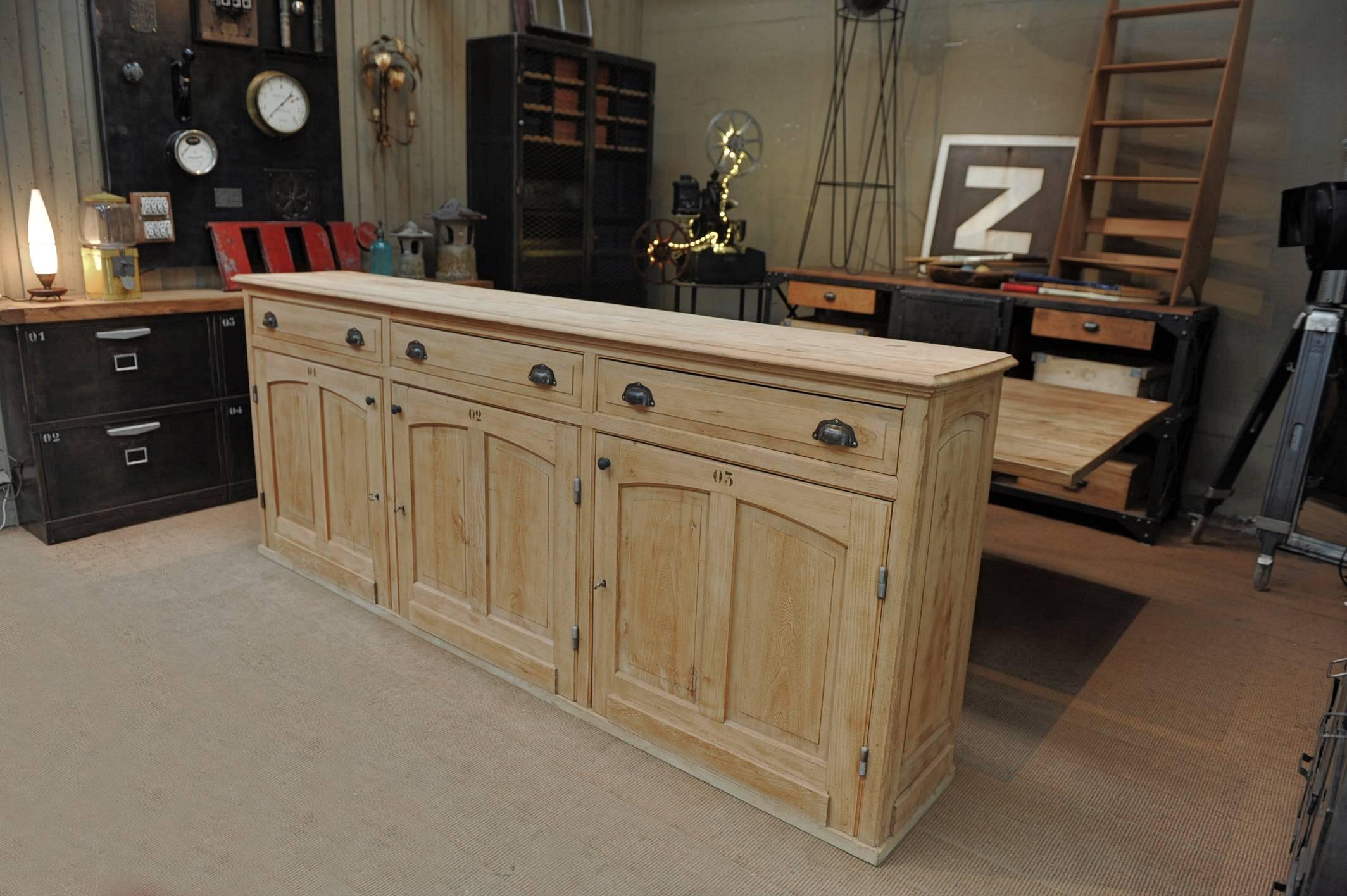 Three doors and three drawers elm wood French shop counter, circa 1930. Natural send finish.

 