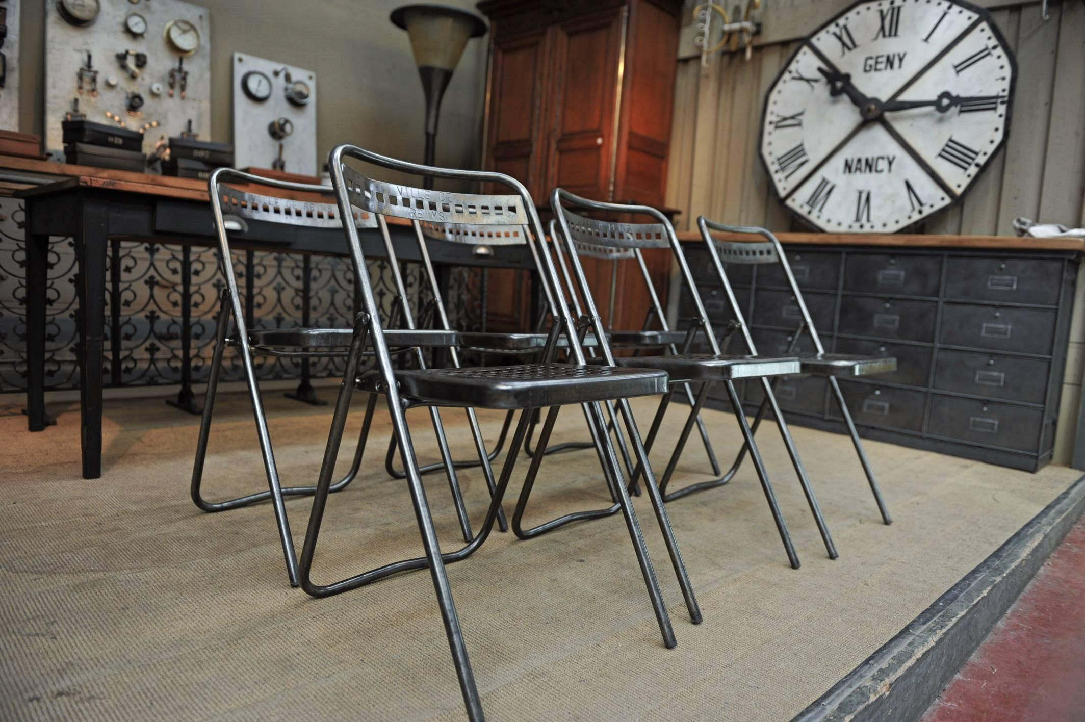Set of six midcentury iron folding chairs from Reims city hall inscription vile de Reims on each back seat, circa 1950
 Polished and Varnish finish for inside use.
Set of six iron folding chairs from Reims city hall (France), circa 1950.